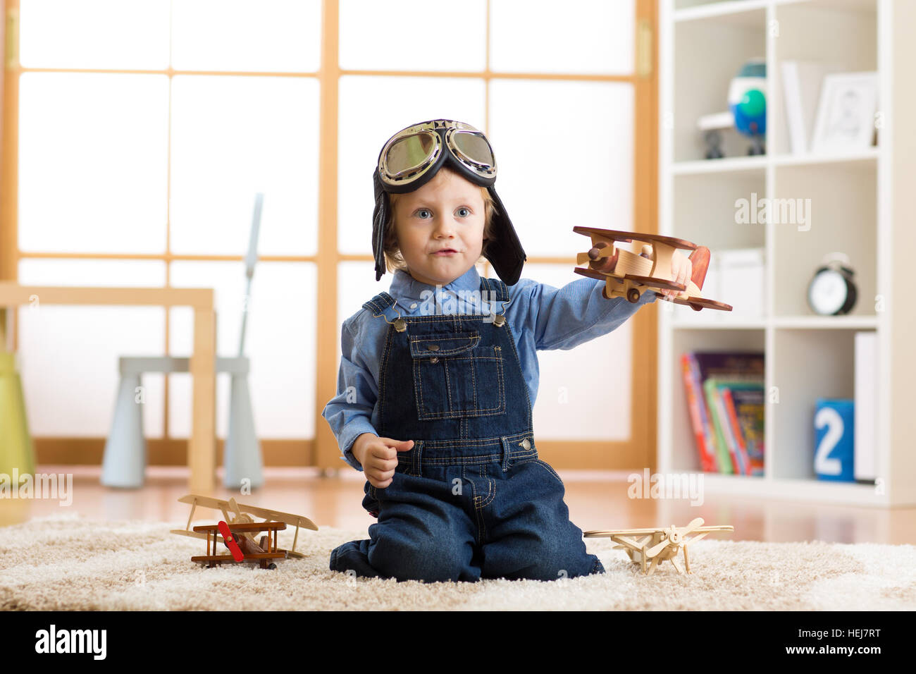 Kind junge vorgibt, pilot zu werden. Kind spielt mit Spielzeug Flugzeuge zu Hause. Reisen und träumen-Konzept Stockfoto