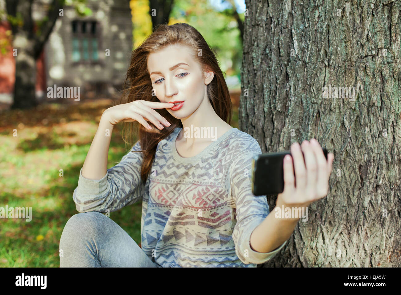 Schöne Mädchen mit blauen Augen macht Selfie im freien Stockfoto