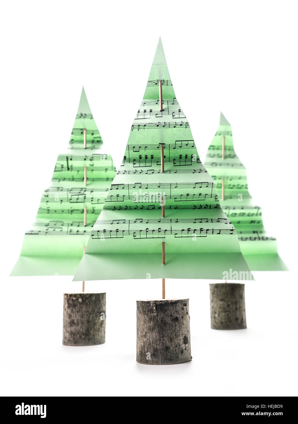 Drei grüne Papier-Weihnachtsbäume mit Christmas carol Notizen auf weißem Hintergrund Stockfoto