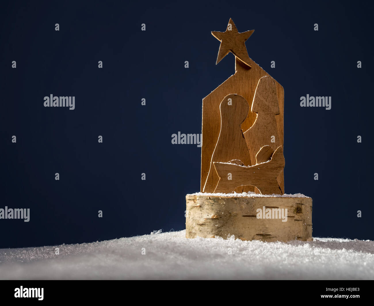 Weihnachtskrippe aus Sperrholz auf dunkelblauem Hintergrund ausgeschnitten Stockfoto