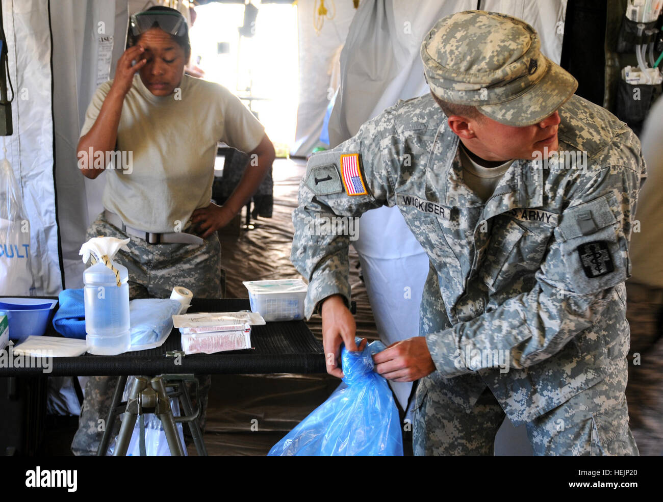 Eilen Sie 629. vorwärts Chirurgenteams des 1st Sgt. Katina Elliot (links), ein OP-Saal chirurgischen Techniker und Sgt. Chris Wickeser, ein Sanitäter und zivilen Feuerwehrmann, zur Vorbereitung auf eine eingehende Medevac. Ein ugandischer Soldat arbeitet auf einer Baustelle wurde von einem Stahlträger in den Kopf getroffen, und die 629th sprang in Aktion, um ihn zu stabilisieren, bis eine Gesichts Platzwunde Nähen und bereiten ihm 200 Meilen südlich über CH-47 Chinook-Hubschrauber in ein Krankenhaus transportiert werden. 629. vorwärts OP-Team rettet das Leben des verletzten ugandischen Soldaten 216211 Stockfoto
