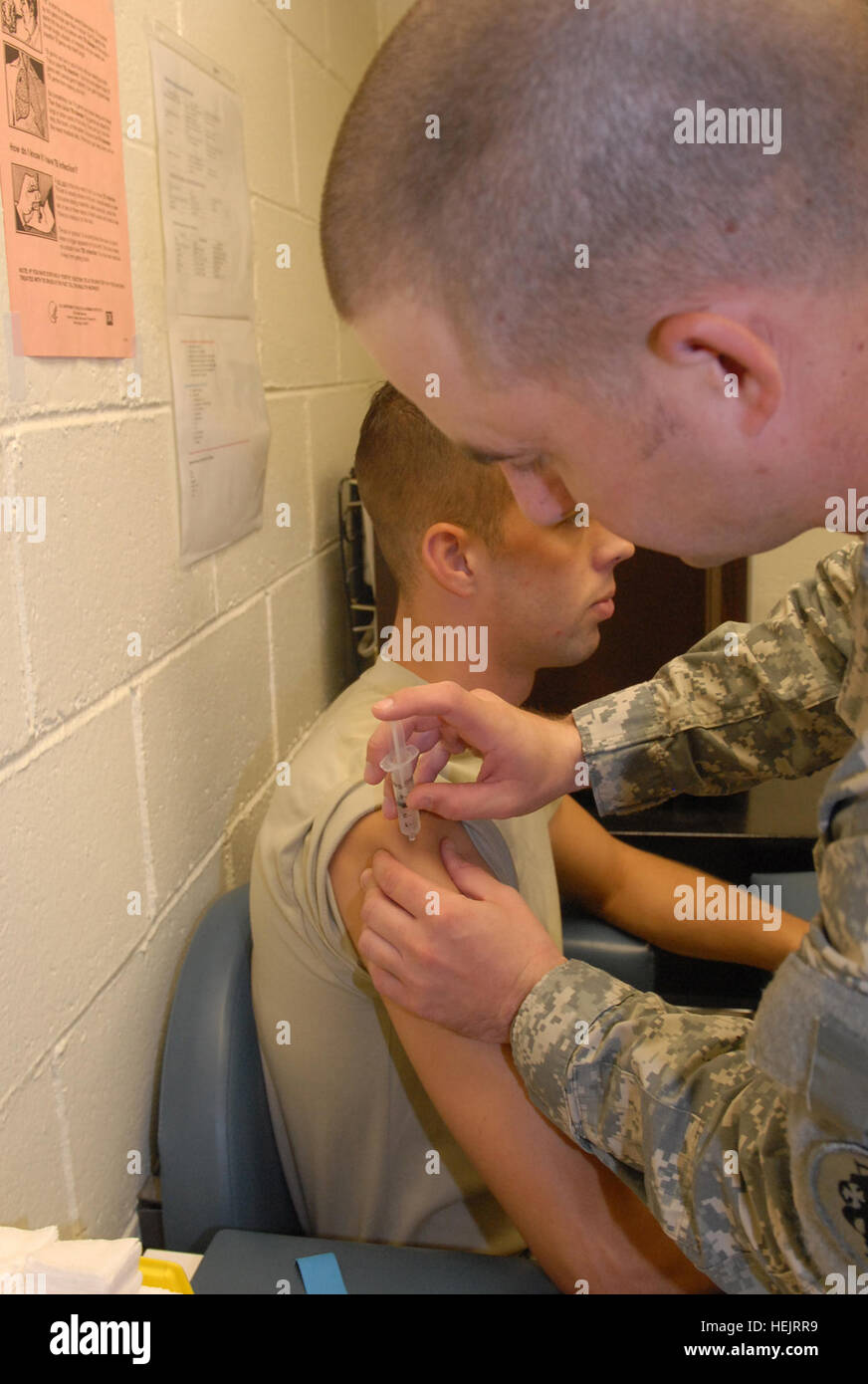 GUANTANAMO BAY auf Kuba – Armee Sgt. Lee McClure, Sanitäter eingesetzt, um die 525th Military Police Battalion, Joint Task Force Guantanamo, verwaltet die Typhus-Impfung zur Armee Spc. John M. Surprenant, JTF gemeinsame Truppe Klinik am US Naval Station Guantanamo Bay, 16. November 2009. Der JTC ist eine erste Linie-Hilfe-Station für JTF Guantanamo Troopers. JTF Guantanamo führt sicher, humane, rechtliche und transparente Pflege und Obhut der Gefangenen, einschließlich der Militärkommission und die verurteilten bestellt von einem Gericht freigegeben. Die JTF führt Intelligenzansammlung, Analyse und Verbreitung für die Stockfoto