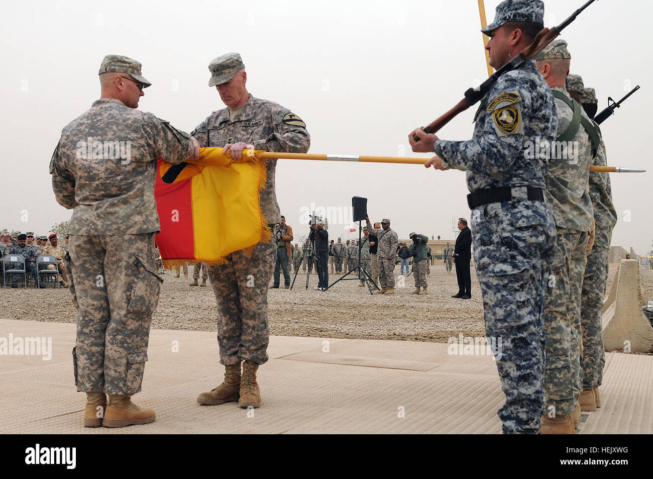 Unterstützt durch Command Sergeant Major Rory Malloy, die Senior eingetragen Unteroffizier verantwortlich für 1.. Kavallerie-Division, Generalmajor Daniel Bolger, Kommandeur der 1. CAV Div. rollt der Division Flagge für Gehäuse während einer Übertragung von Autorität Zeremonie durchgeführt am 13. Januar im Camp Liberty. Übernahm die ersten Armored Division des US-Division-Center Arbeitsumfeldes aus 1. Cav. Div. Iron Soldaten übernehmen Verantwortung für Bagdad Betriebsumgebung 239542 Stockfoto