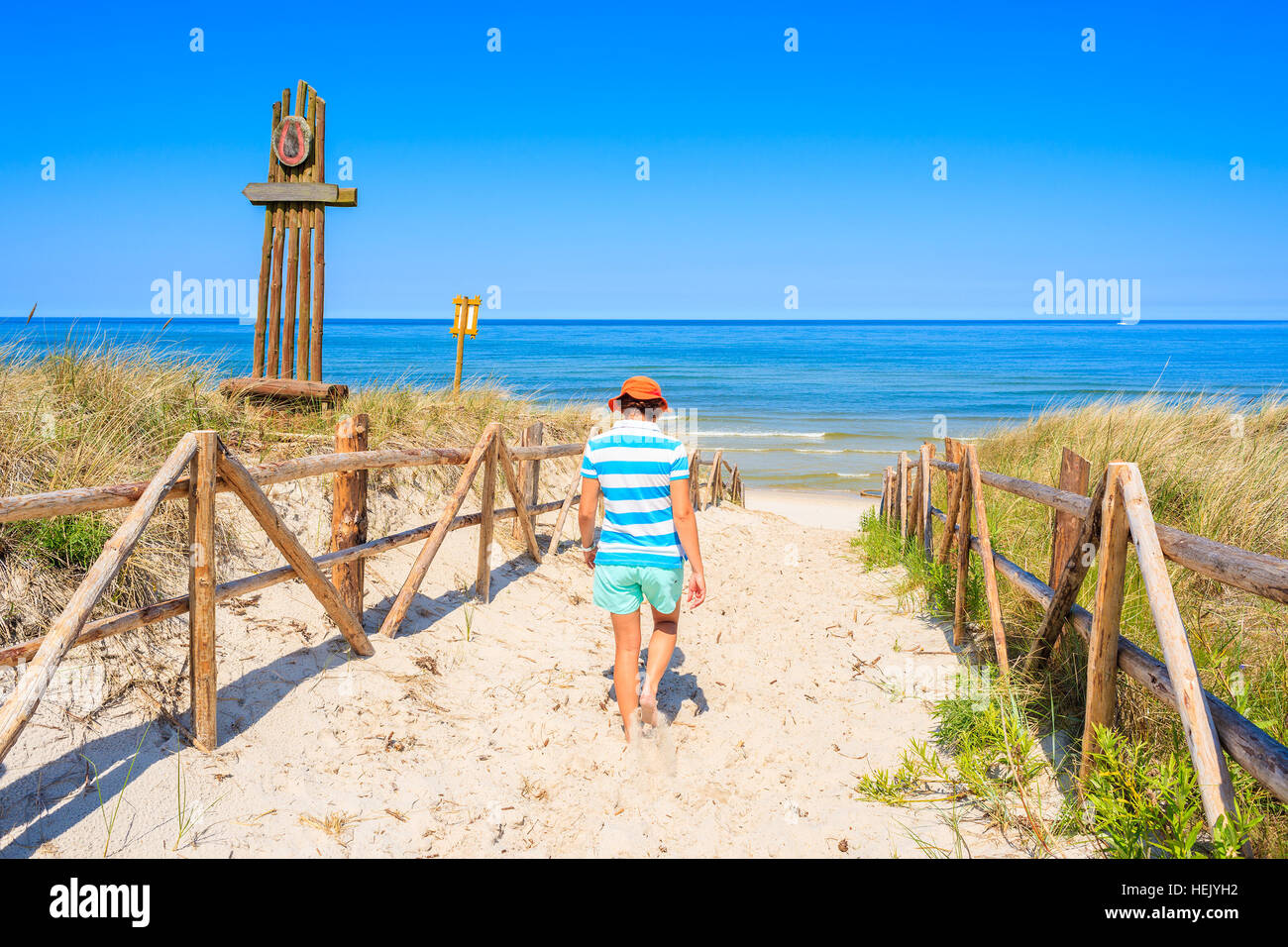 Junge Frau zu Fuß zum Sandstrand in Lubiatowo Dorf, Ostsee, Polen Stockfoto