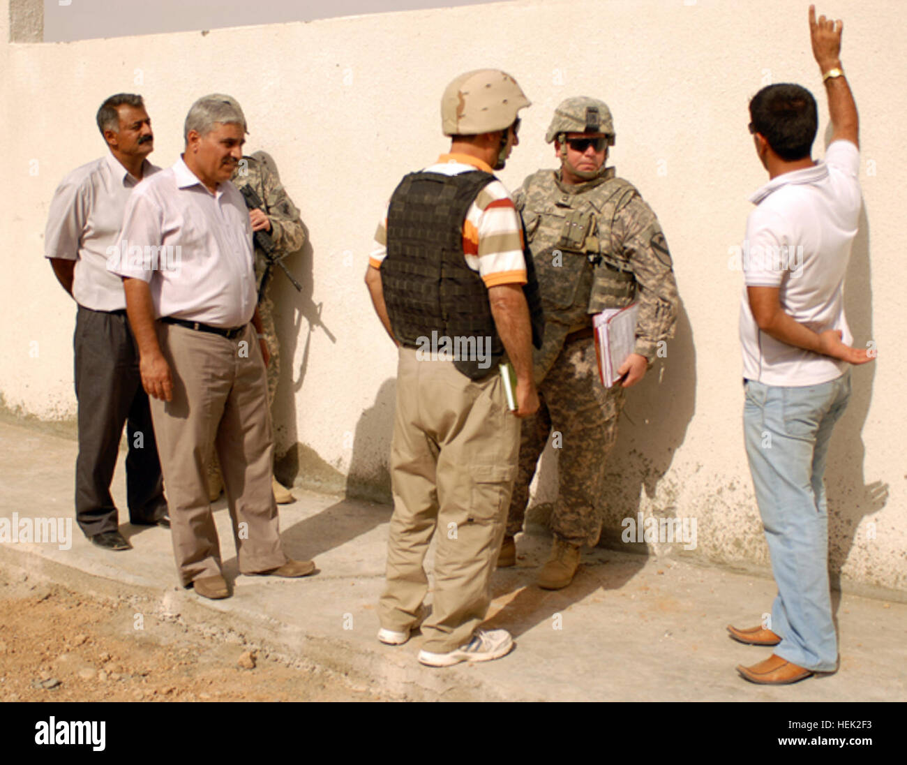 Sgt. 1. Klasse Carl Lay, Carrollton, Texas, geboren und der Grundversorgung Vertreter für 2nd Brigade Combat Team, 1. Kavallerie-Division, spricht mit einer der Ingenieure auf dem Gelände einer neuen Schule in Chemin, Irak, Sept. 8 gebaut. Die neue Schule wird die Kindern der Umgebung unterstützen und geben den Schülern viel mehr Platz zum lernen. Irakische Kinder gehen aus Lehmhütte zur Schule, neue 204668 Stockfoto