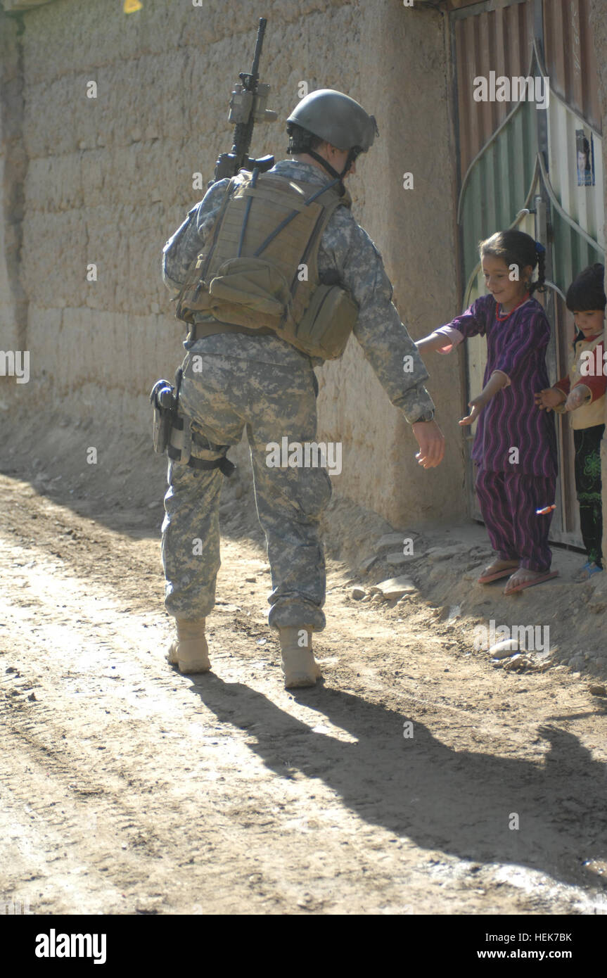 Major Mike Roth, Special Operations Task Force East, verteilt Süßigkeiten an Kinder während einer Patrouille von Jan Qadam Dorf, Bagram Bezirk, Parwan Provinz, Afghanistan November 10. SOTF-E Soldaten sprach mit den Anwohnern und Rapport mit dem Dorf, auf ältere, Frauen, Männer und Kinder gegründet. (Foto: U.S. Air Force 1.. Lt. Neil Samson) (Freigegeben) Jan Qadam Dorf Präsenz Patrouille 339076 Stockfoto