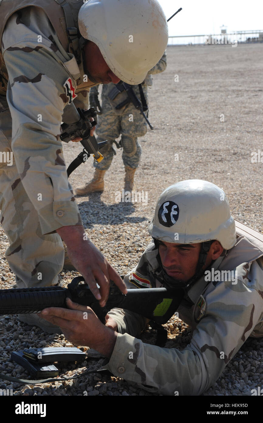 Eine irakische Armee Soldat, Gruppenführer, 2. Kompanie, 1. Bataillon, 28. mechanisierte Brigade, 7. irakische Armee-Division zugewiesen prüft seinen Kader Waffe Status im Camp Al Asad, Irak, 10. Februar 2011. US-Soldaten zugewiesen, Alpha Company, 3. Bataillon, 7. Infanterie-Regiment, 4. beraten und unterstützen Brigade, 3. US-Infanteriedivision und 4. "Black Jack" Geschwader, 10. Kavallerie-Regiment, 3. beraten und unterstützen Brigade, 4. US-Infanteriedivision unterstützende irakische Armee Soldaten im Kader Bewegungstraining zur Unterstützung der Operation New Dawn. Black Jack-Geschwader in Camp Al Asad 368079 Stockfoto