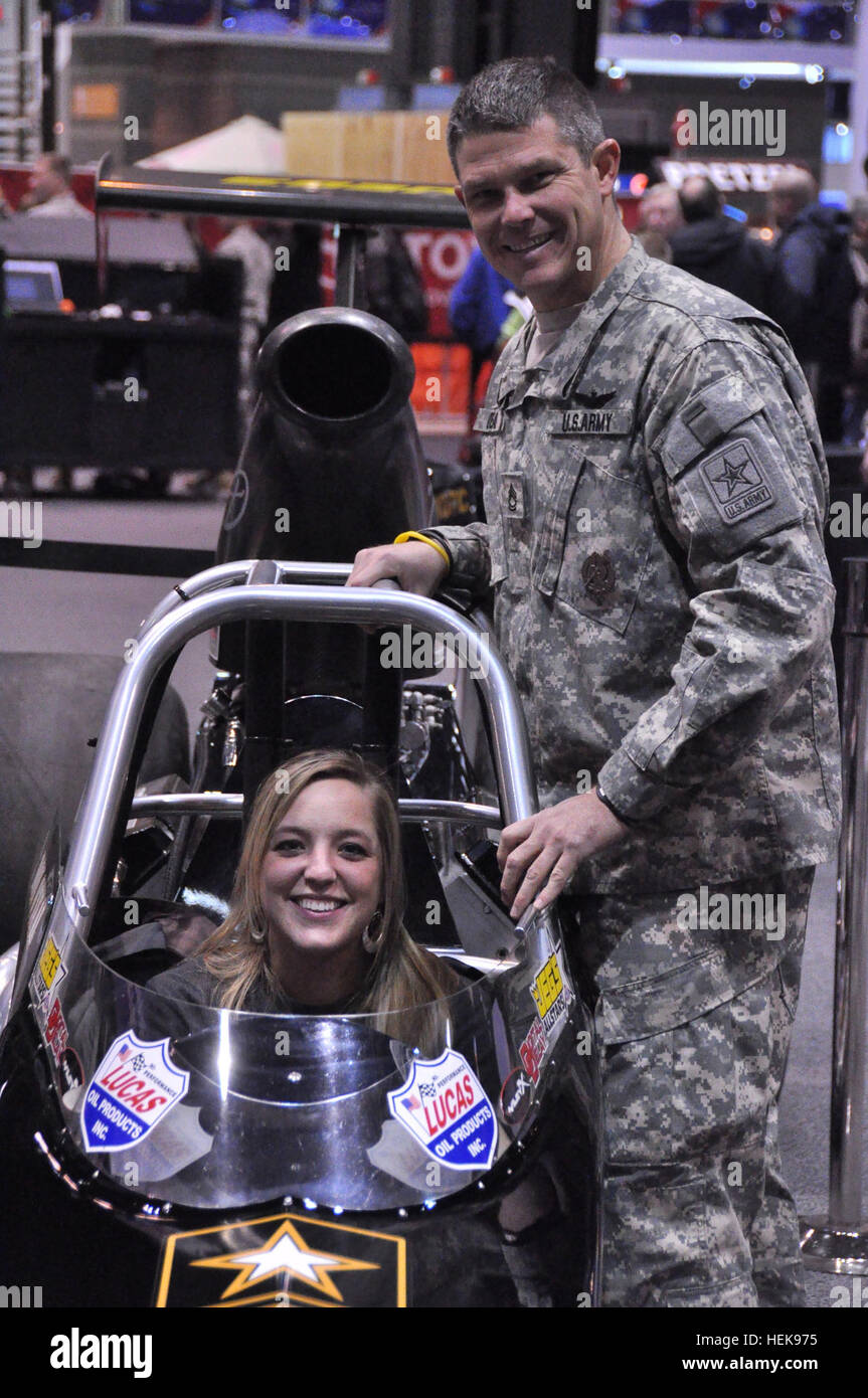 NHRA Treiber Sgt. 1. Klasse Don O'Neal hilft die Gewinner des Wettbewerbs weibliche Liegestütze in seinem Rennwagen. (US Armee-Foto von Annie Chambers) Armee zeigt Rüstung auf der 2011 Chicago Auto Show 370809 Stockfoto