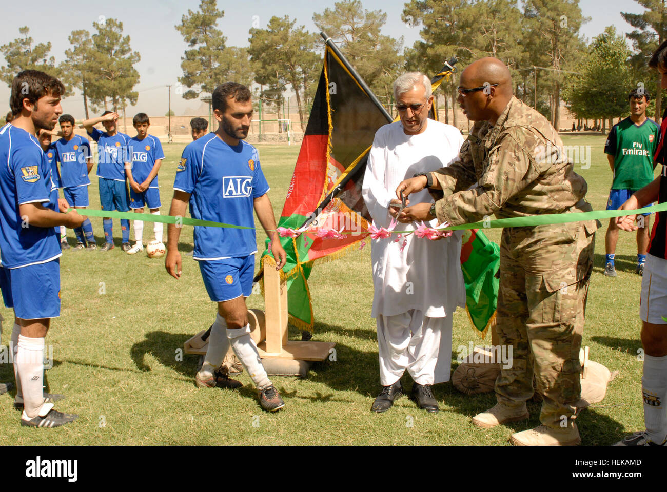 KANDAHAR, Afghanistan - Captain Derrick W. Tau, Kommandant, 202. Military Police Company derzeit zugeordnet zu 1st Brigade Combat Team, Task-Force "Raider", 4. US-Infanteriedivision, übergibt der Schere Stadt Kandahar Bürgermeister, Haider Hamedi während einer Banddurchtrennungszeremonie, die die offizielle Eröffnung des einen neuen Fußballplatz im Ortsteil eines Kandahar Stadt bedeutete. Das neue Feld war eines von vielen Projekten, die unter der Leitung von 1st Brigade Combat Team, TF "Raider", 4. US-Infanteriedivision und ihre afghanischen nationalen Sicherheitskräfte Partner bei ihren Joint-Rekonstruktion Bemühungen zur Verbesserung der Lebensqualität, s Stockfoto