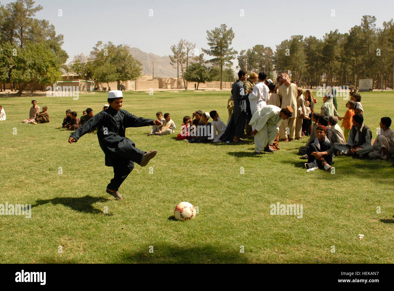 KANDAHAR, Afghanistan - spielt ein afghanischer Junge aus dem "Alten Corps" Bereich der Stadt Kandahar während ein Fußballspiel zwischen zwei lokalen Teams 8. Juni mit einem neuen Fußball. Das Spiel kam nach einem Banddurchtrennungszeremonie die Einweihung eines neuen Fußball-Felds in einem Ortsteil der Stadt Kandahar bedeutete. Das neue Feld war eines von vielen Projekten, die unter der Leitung von 1st Brigade Combat Team, TF "Raider", 4. US-Infanteriedivision und ihre afghanischen nationalen Sicherheitskräfte Partner bei ihren gemeinsamen Wiederaufbau Bemühungen zur Verbesserung der Lebensqualität und Sicherheit für die Bewohner der Stadt Kandahar. (US-Armee Stockfoto