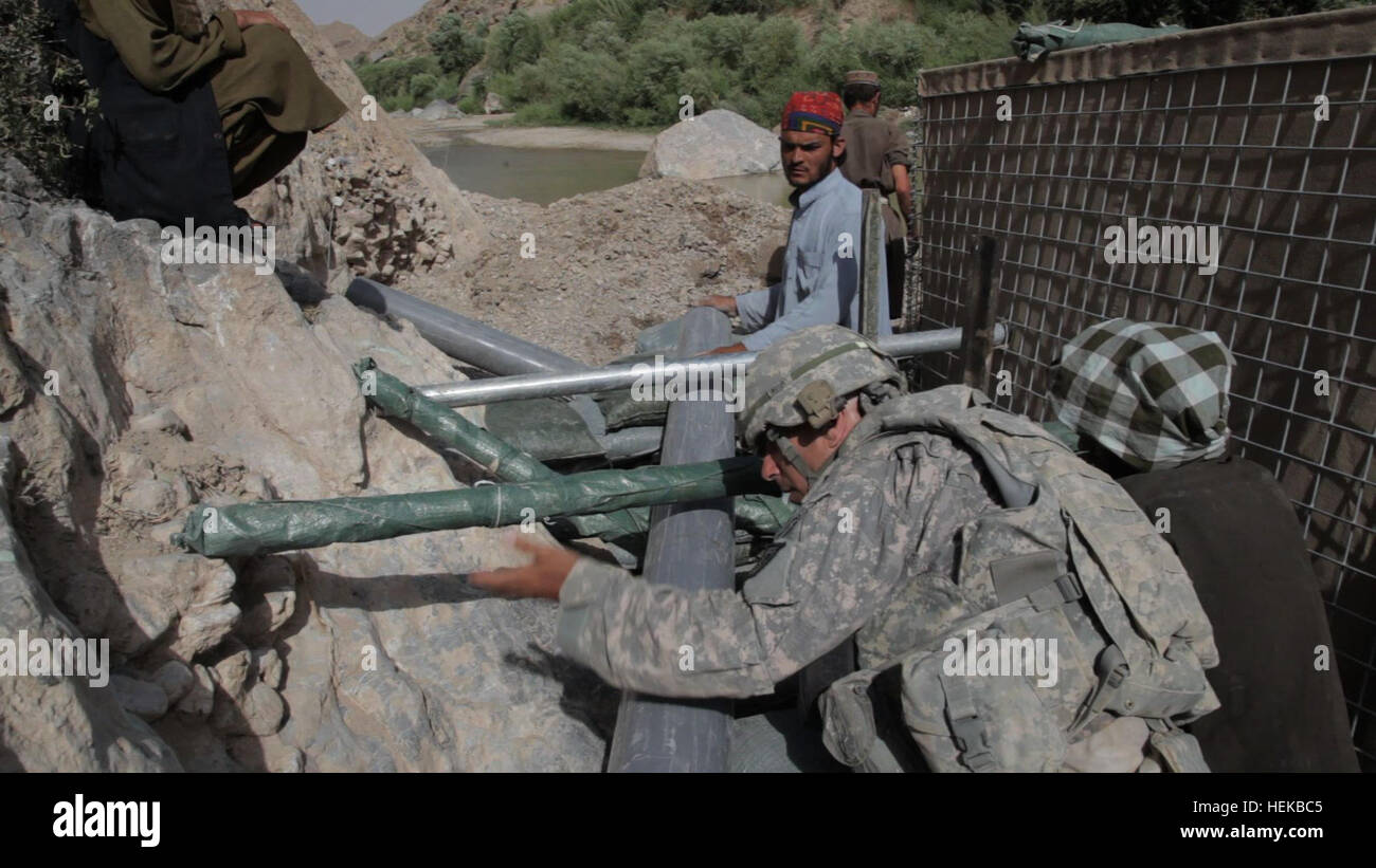 Afghanischen lokalen Staatsangehörigen beistehen U.S. Army Soldaten zugewiesen, die Nationalgarde Arkansas in den Bau eines Staudamms in der Nähe von bekämpfen Betrieb Post Mizan in Zabul, Afghanistan, 1. Juli 2011. Der Damm wird gebaut, um den Wasserfluss zu verschiedenen Bewässerungssysteme in der gesamten Region zu kontrollieren. Dammbau 110701-A-UJ825-002 Stockfoto