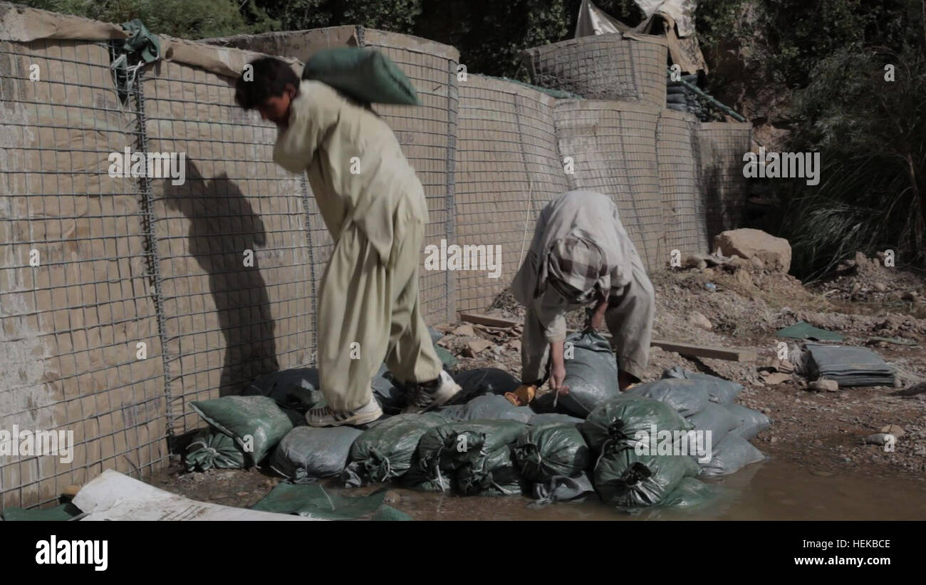 Afghanischen lokalen Staatsangehörigen beistehen U.S. Army Soldaten zugewiesen, die Nationalgarde Arkansas in den Bau eines Staudamms in der Nähe von bekämpfen Betrieb Post Mizan in Zabul, Afghanistan, 1. Juli 2011. Der Damm wird gebaut, um den Wasserfluss zu verschiedenen Bewässerungssysteme in der gesamten Region zu kontrollieren. Dammbau 110701-A-UJ825-008 Stockfoto