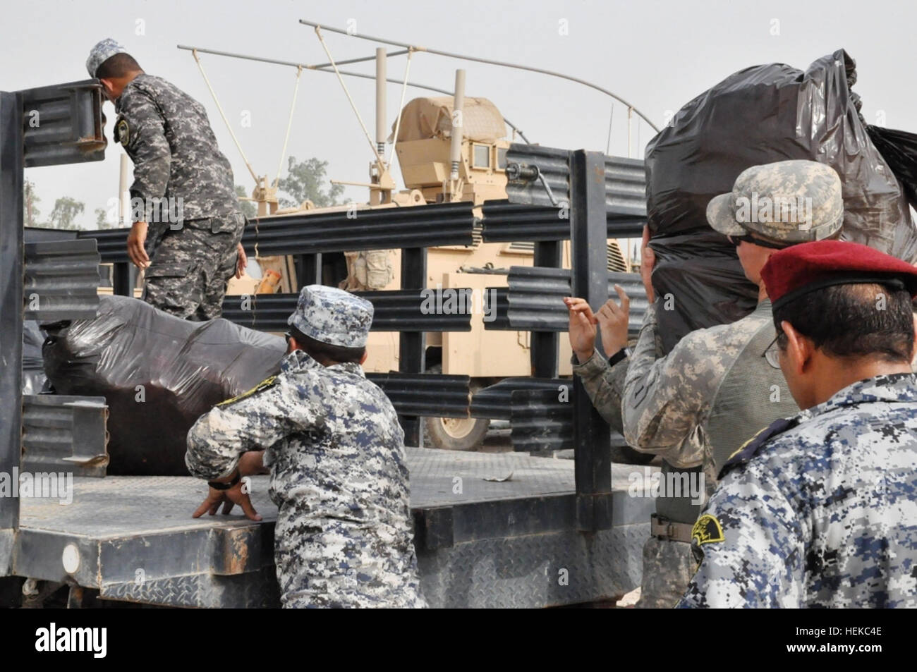 US-amerikanische und irakische Streitkräfte verteilten Sportausrüstung an die örtliche Gemeinde der Joint Security Station Constitution im Irak, um Freizeitprogramme und die Entwicklung der Jugendliga nach dem ersten Fußballspiel auf dem Al Ghazaliyah Field zu unterstützen. Stockfoto