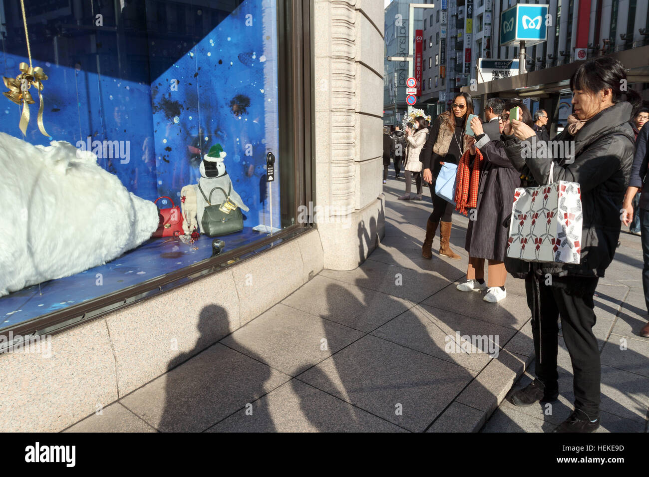 Ginza Shopper Fotografieren ein riesiger Eisbär auf dem Display an Wako Kaufhaus am 21. Dezember 2016, Tokio, Japan. Die Schaufensterauslage umfasst eine große Bärin mit zwei Babys schlafen. Fußgänger dürfen Aufwachen der größte Bär treibt eine Unterseite, die sagt, "Bitte nicht stören." © Rodrigo Reyes Marin/AFLO/Alamy Live News Stockfoto