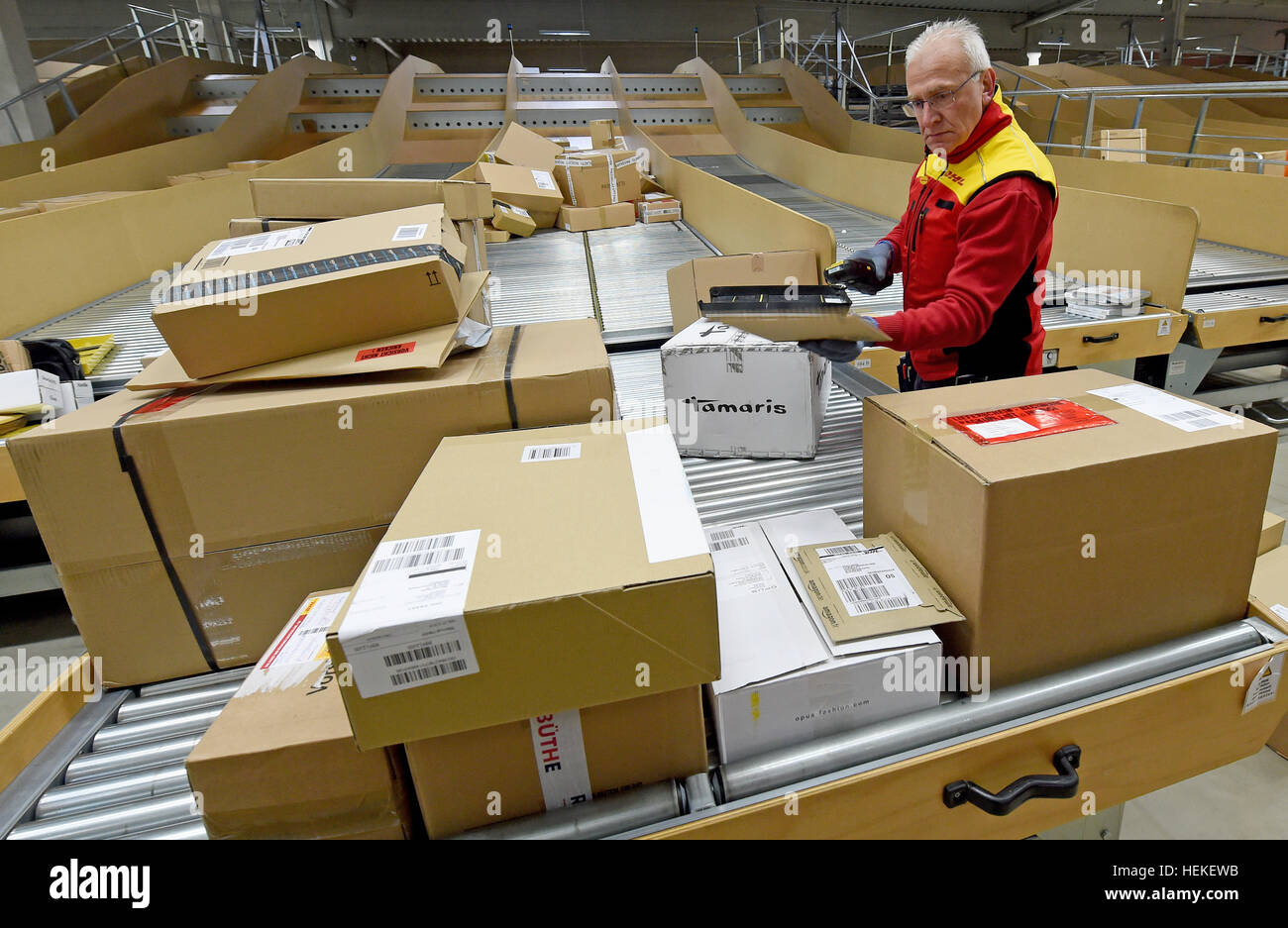 Paket-Zusteller, die Hans-Joachim Harnagel liest den Code auf ein Paket mit einem Scanner bei der DHL-Lieferung Basis Braunschweig, Deutschland, 21. Dezember 2016. Danach wird Harnagel 280 Päckchen und Pakete an ihre Empfänger während einer Reise durch die Innenstadt von Braunschweig liefern. Foto: Holger Hollemann/dpa Stockfoto