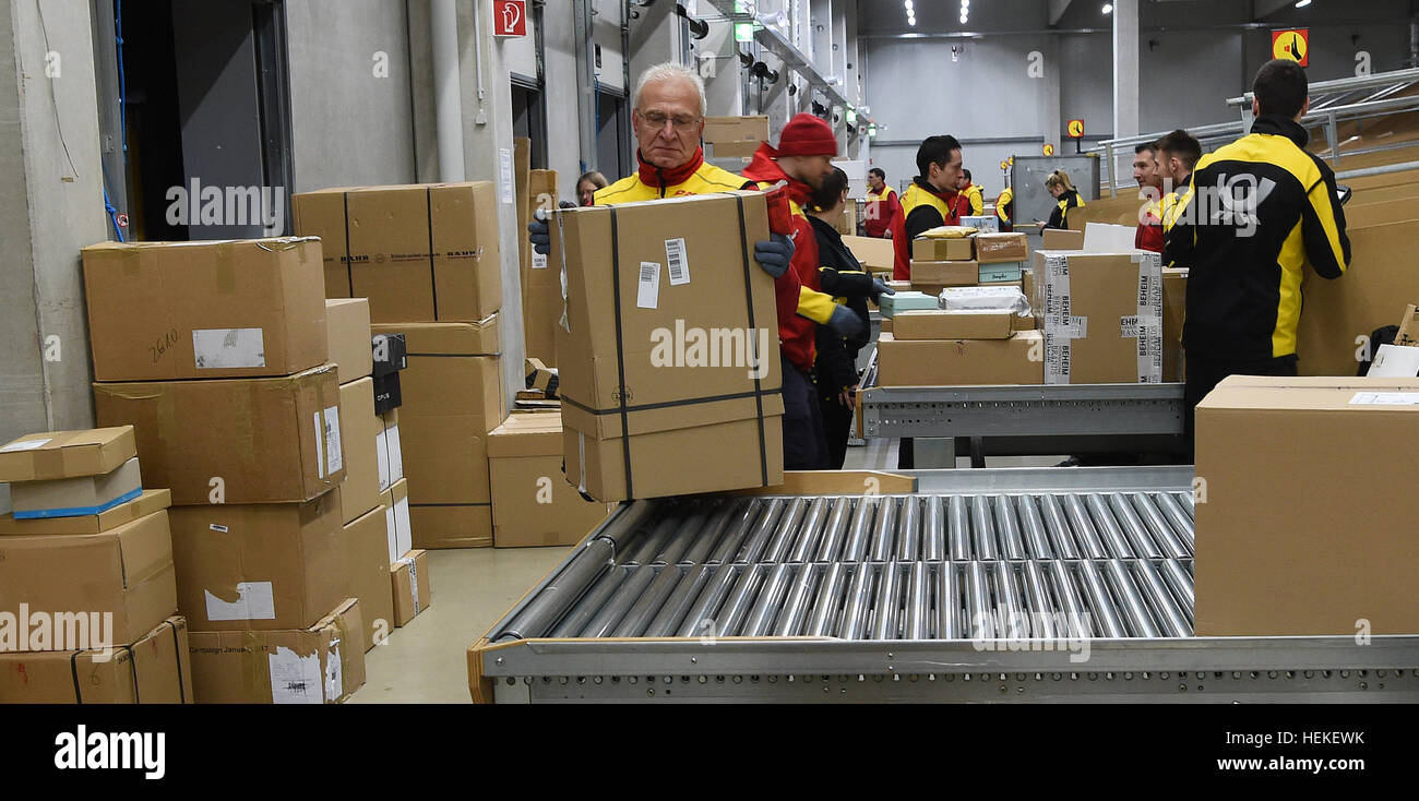 Braunschweig, Deutschland. 21. Dezember 2016. Die Paket-Zusteller Hans-Joachim Harnagel nimmt eine Paket aus dem Förderband auf die DHL-Lieferung in Braunschweig, Deutschland, 21. Dezember 2016. Rund 280 Päckchen und Pakete liefern wir an ihre Empfänger während einer Reise durch die Innenstadt von Braunschweig. Foto: Holger Hollemann/Dpa/Alamy Live News Stockfoto
