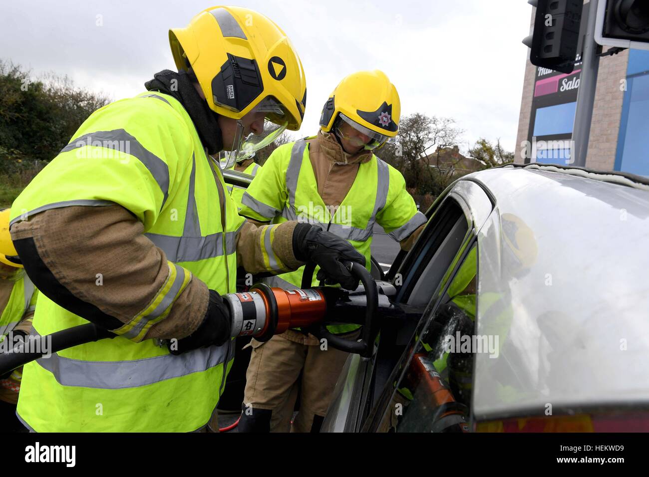 Feuerwehrmann, schneiden Sie das Dach eines Autos bei der Szene einer Unfall-Demonstration, UK. "Autounfall" Szene, RTA oder RTC, abgestürzt Auto mit Feuerwehr-Arbeit Stockfoto