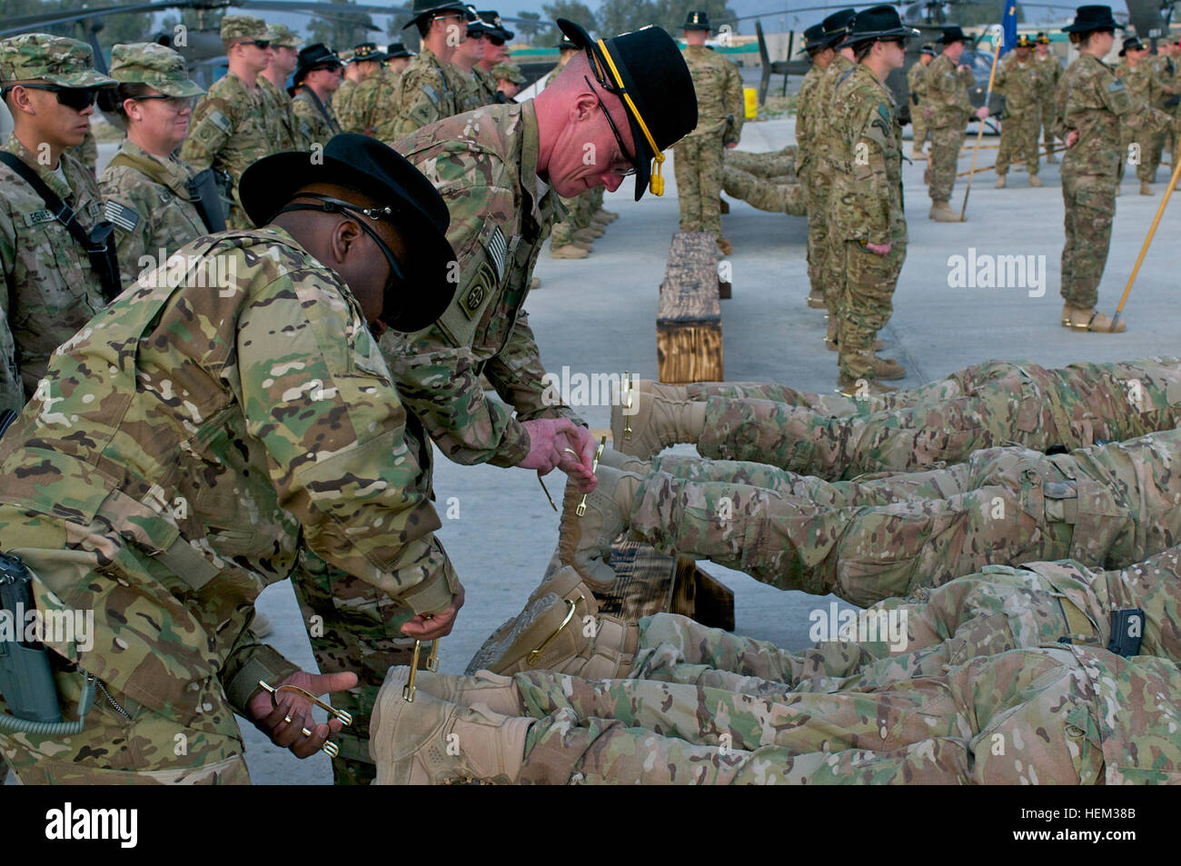 US Army Spc. Christopher Lambert, von Mailand, Ohio, übernimmt die Liegestütz-Position während 1st Sgt. Byron Yeager, der Cove City, North Carolina, gold Kampf stellt auf seinen Füßen 2. März anspornt. Lambert und Yeager dienen beide mit 82nd Combat Aviation Brigade, Task Force Saber, in der Nähe von Jalalabad, Afghanistan.  Goldene Sporen präsentieren Kavallerie Troopers dienen mehr als 30 Tage im Kampf in einer Kavallerie-Einheit, eine US-Kavallerie Tradition stammt aus dem Bürgerkrieg. Kampf gegen Spurs 536704 verdienen Stockfoto