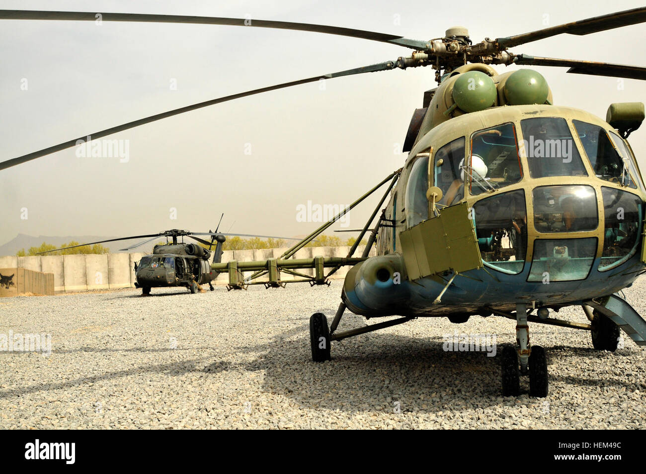 Ein Mi-17 Hubschrauber von der Kandahar Air Wing und UH-60 Black Hawk Hubschrauber vom 2. Bataillon, 25. Aviation Regiment, 25. Combat Aviation Brigade erwarten richtige Ladevorgänge, die Ausbildung von afghanischen und Koalition Kräfte während einer Luft Angriff Probe auf Vorwärts operative Basis Shoja, Afghanistan, 31.März. Afghanische Kräfte arbeiten zusammen während Angriff Luftoperationen 120331-A-UG106-004 Stockfoto