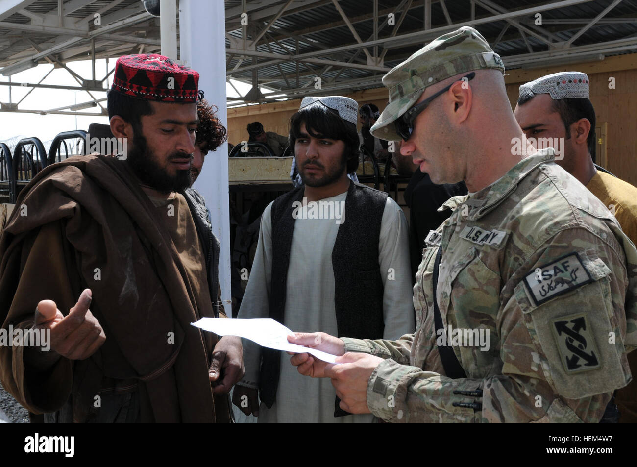 US Army Reserve Staff Sgt Derek Cutter, Unteroffizier verantwortlich für Kandahar Flugplatz Eintrag Control Punkt fünf, 558th Mission Control Team, 143. Expeditionary Support Command, spricht mit lokalen nationalen LKW-Fahrer auf Kandahar Flugplatz. Einsatz zur Unterstützung der Operation Enduring Freedom, Tampa, Florida, - basierte Einheit ist verantwortlich für den kontrollierten Zugang der Mehrheit der LKW kommen in und aus der Basis. Zutrittskontrolle - team die Ins und Outs der Bewegungskontrolle eine Armee 230412-A-SD827-001 Stockfoto