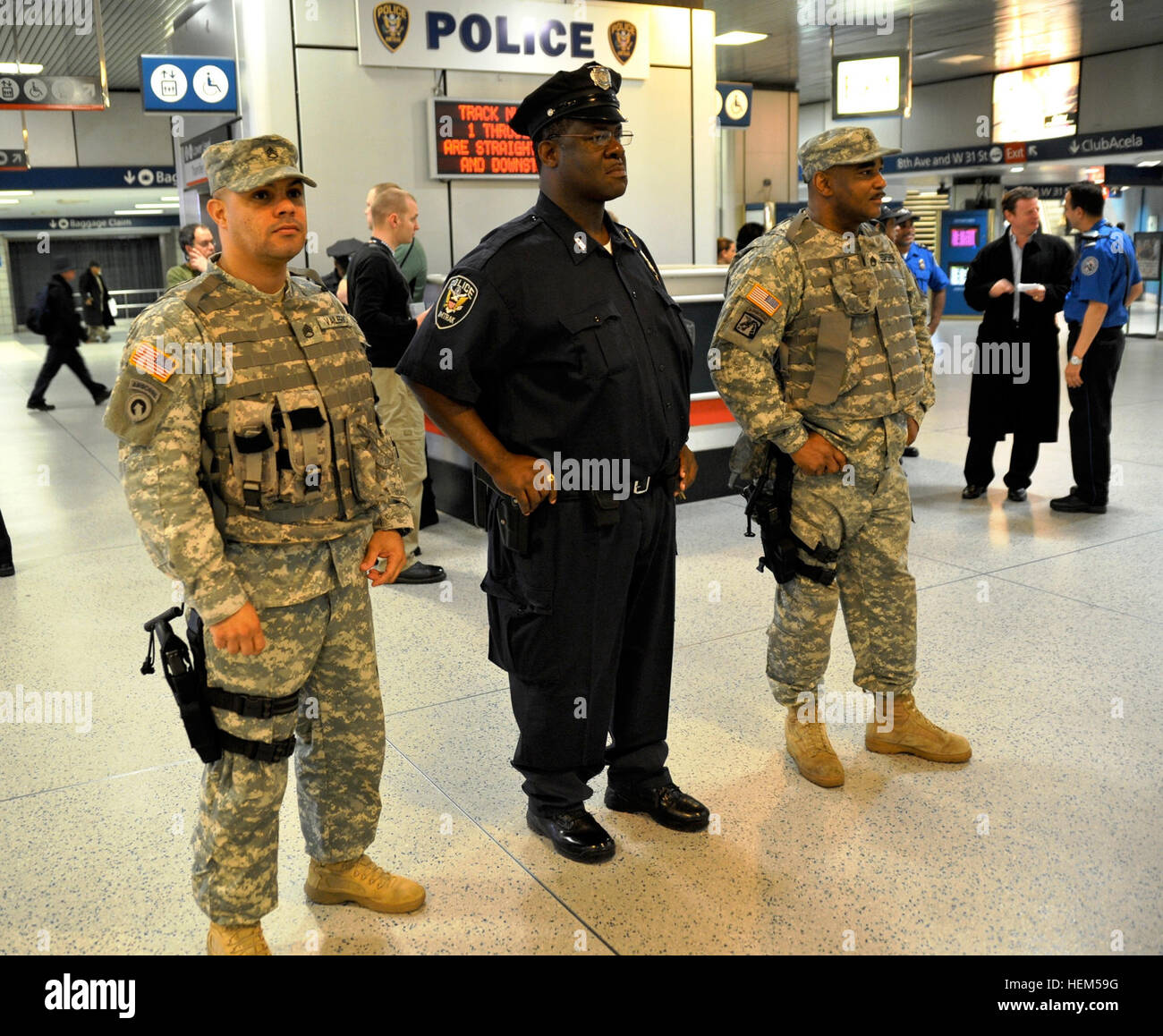 New York Army National Guard Staff Sgt Victor Valerio (links) und Staff Sgt Ronnie Redfern Sicherheit Pflicht in Pennsylvania Station am Mittwoch, 2. Mai mit einem Amtrak Polizist ziehen. Die Soldaten sind Mitglieder der New Yorker Nationalgarde gemeinsame Task Force Empire-Shield bietet Sicherheit Brustvergrößerung an Strafverfolgungsbehörden an Verkehrsknotenpunkten im Großraum New York. Das Team war Teil der eine behördenübergreifende Super Surge (Masse) in der Polizei wichtige Transport-Knoten zur Abschreckung von Angriffen sättigen. Mai 2 Masse war der 100. Mal New York National Guard unterstützt diese Art von s Stockfoto