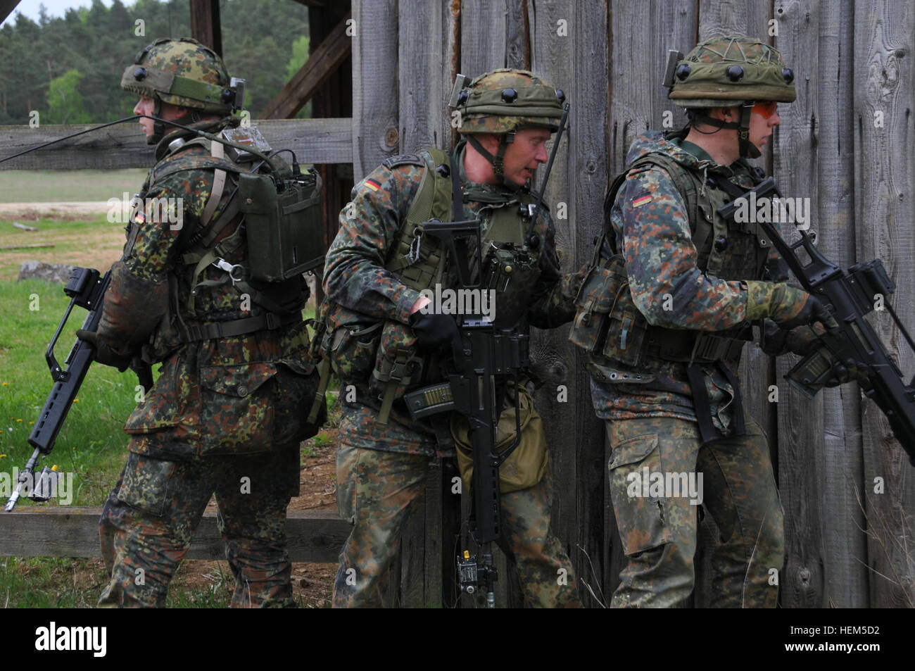 Deutsche Soldaten aus 371. Infanterie-Bataillon vorzubereiten, ein Gebäude während einer Übung Operational Mentor Liaison Teams (OMLT) auf das Joint Multinational Readiness Center in Hohenfels, Deutschland, 5. Mai 2012 zu suchen.  OMLT XXIII und Polizei Operational Mentor Liaison Team (POMLT) VII Ausbildung sollen vorbereiten Teams für den Einsatz in Afghanistan mit der Fähigkeit zu trainieren, beraten, ermöglichen die Afghan National Security Force in Bereichen wie Bekämpfung von Aufständen, Beratung zu bekämpfen und förderlichen Maßnahmen zu erzwingen. (US Armee-Foto von Sgt. Kirk Evanoff/nicht veröffentlicht) NATO operative Stockfoto