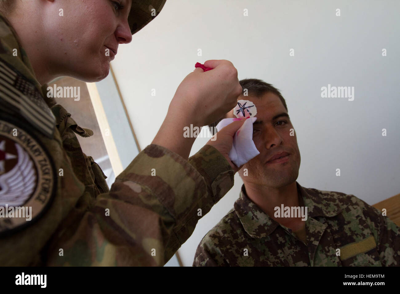 US Air Force Captain Andrea Hickman, der medizinischen Beratung Trainingsgruppe Teamleiter mit regionaler Unterstützung Befehl Südwesten, NATO Training Mission Afghanistan gilt Kunstblut und eine Ausbildungshilfe auf einem simulierten Unfall gespielt von Afghan National Army Soldaten vor eine mass Casualty Übung für die ANA auf Lager Shorabak, Provinz Helmand, Afghanistan, 9. September 2012. Die Übung fand um ANA medizinischen Personals auf Lager Shorabak organisieren und optimieren ihre mass Casualty Behandlungspläne zu helfen. (US Armee-Foto von Bill Putnam/freigegeben) Mass Casualty ANA Übung 120909-A-YI377-0026 Stockfoto