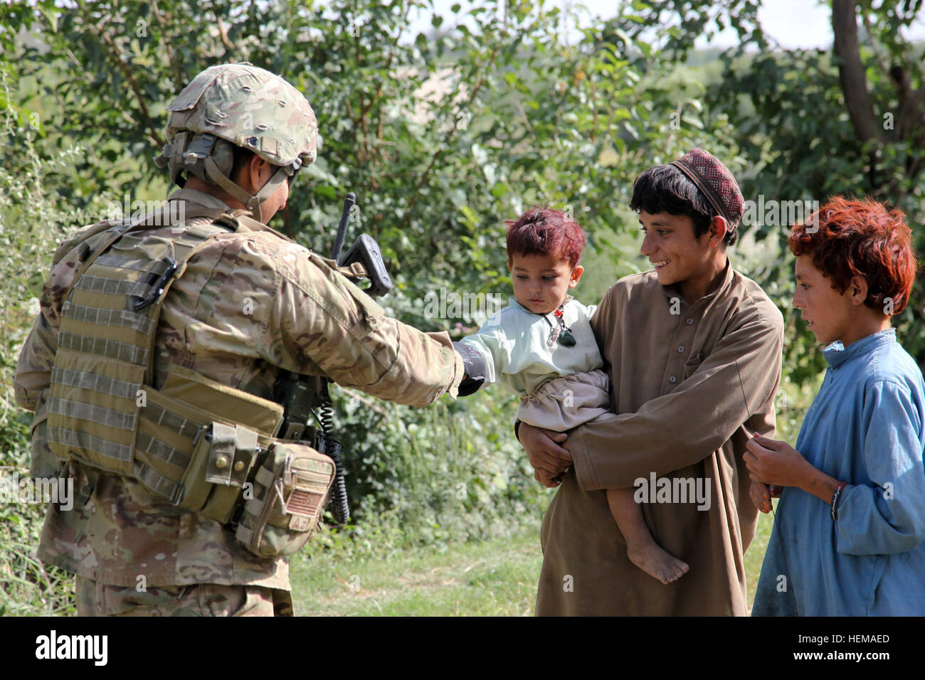 US-Sergeant Jaime Esparza serviert mit Delta Company, 1st Battalion (Airborne), 143. Infanterie-Regiment, Task Force, district 4-25, provinzielle Rekonstruktion-Mannschaft Khost, spielt mit einem Kleinkind während eines Besuchs in einem Bauerndorf in der Nadir Schah Kot, Provinz Khost in Afghanistan, 27. September 2012. Die Khost PRT besuchte Bauern um ihre wachsenden Bedingungen und der Versorgung zu besprechen. Provincial Reconstruction Team 120927-A-PO167-030 Stockfoto