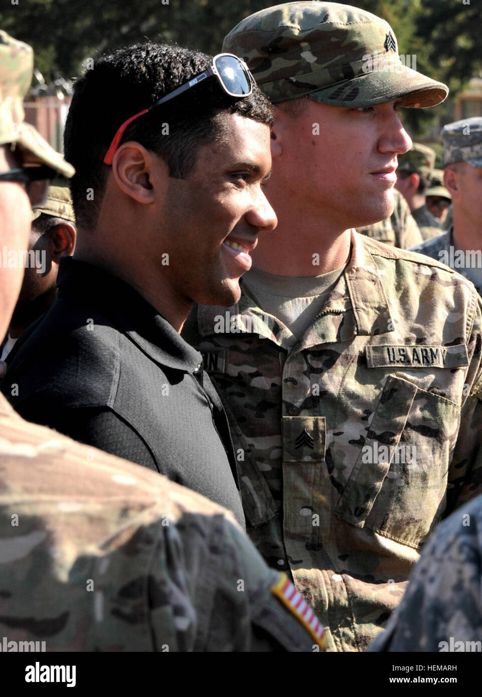 JOINT BASE LEWIS-MCCHORD, Washington – Russell Wilson, Quarterback mit den Seattle Seahawks-Fußball-Nationalmannschaft, posiert für ein Foto mit einem Soldaten aus dem 4. Stryker Brigade Combat Team, 2nd Infantry Division bei einem informellen Treffen und grüßen Veranstaltung am Manchu Feld hier Okt. 9. Russell Wilson mit Marines Stockfoto