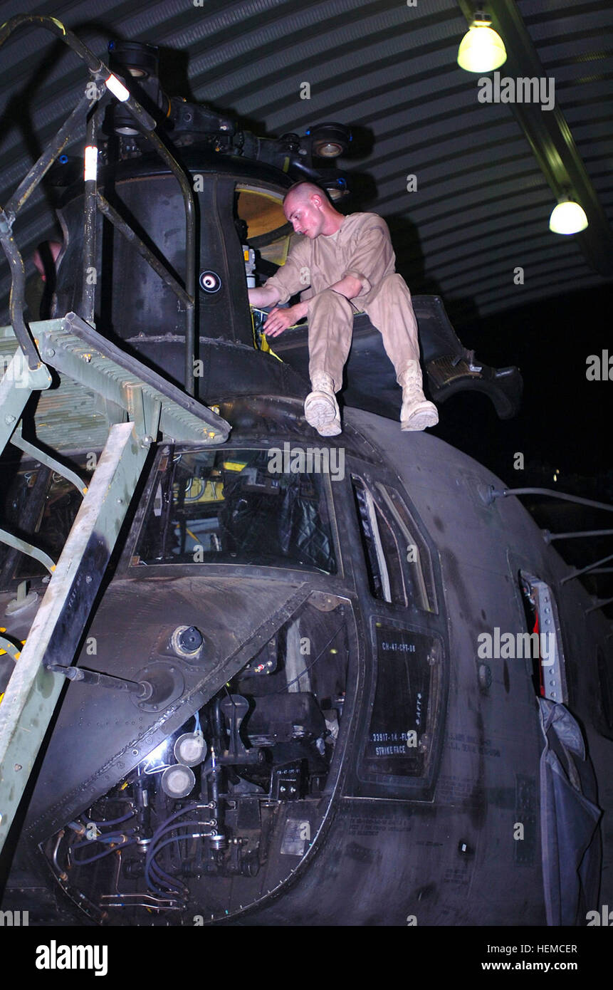 Während viele Soldaten auf Camp Taji, Irak, Shapleigh, Maine, Native Spc. Edward Burnell, schlafen ein CH-47 Chinook Hubschrauber Mechaniker für Firma D, 2. "Lobo" Bataillon, 227. Aviation Regiment, 1st Air-Kavallerie-Brigade, 1. Kavallerie-Division, liegt hoch über dem Boden auf dem vorderen Pylon ein Chinook wie er arbeitet, um das Gehäuse zu befestigen. (US Armee-Foto von Spc. Nathan J. Hoskins, 1. Air Cavalry Brigade Public Affairs) Es wurde eine "hard Day Night', Aviation Schreib 45883 Stockfoto