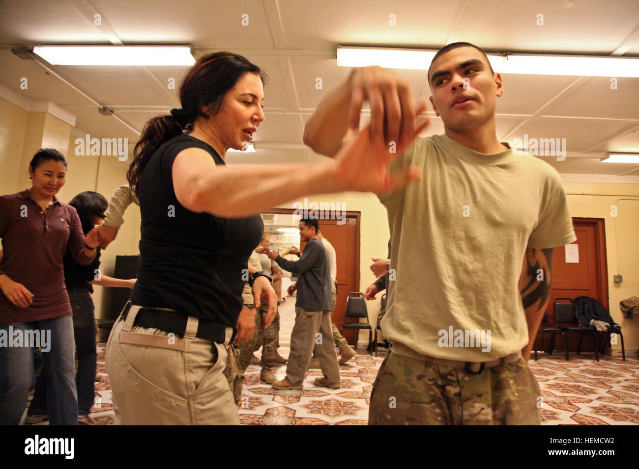 Tanzlehrer Inara McKinney Tänze mit Pfc. Raul Galvan dienen mit 571st Military Police Company während einen Salsa-Tanzkurs von der Moral, Wohlbefinden und Erholung (MWR) auf Forward Operating Base Fenty organisiert, Provinz Nangarhar, Afghanistan, 18. Dezember 2012. Die MWR bietet Dienstleistungen und Aktivitäten, die die Leben der Soldaten kulturell und kreativ bereichern. (US Armee-Foto von Spc. Jenny Lui/freigegeben) Salsa-Tanzkurs 121218-A-TT389-135 Stockfoto