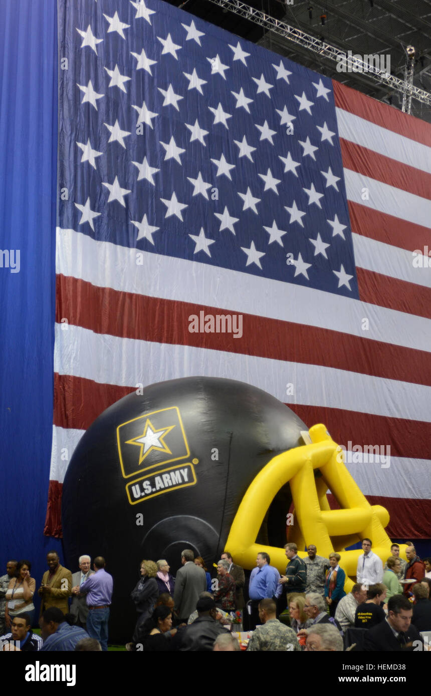 Soldaten trat Nachwuchsathleten und Musiker und ihre Familien für ein Texas-Style Barbecue-Dinner an der Alamodome in San Antonio 3. Januar 2013. Das Abendessen war nur eine von vielen Aktivitäten in der ganzen Stadt an der US-Armee All-American Bowl, Jan. 5 stattfinden. Die amerikanische Flagge und Ballon-Helme, vertreten beide Mannschaften im Spiel, wurden auf dem Display während des Abendessens. Die Armee war Gastgeber der All-American Bowl in San Antonio seit 2002, Hervorhebung der 90 besten High School Fußballspieler und 125 besten Highschool marching Band Musiker aus dem ganzen der Stockfoto