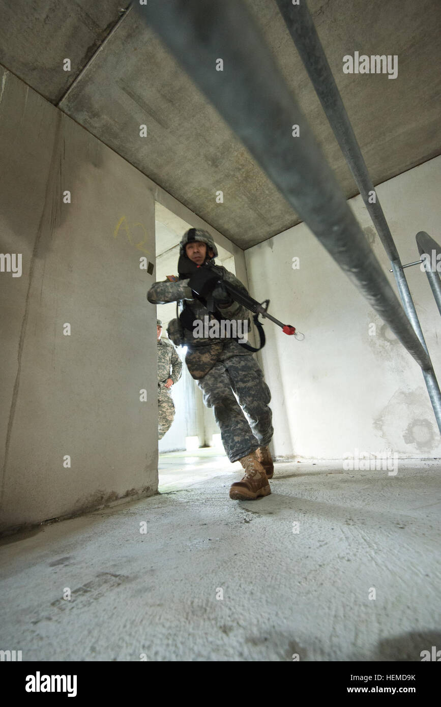 US Army Staff Sgt Bertin Salgado aus USA-NATO-Brigade, Form-Bataillon, läuft in einen anderen Raum als die Einheit ein Gebäudes in einem städtischen Betrieb während einer Standardübung auf Alliance Training Area, Chièvres Air Base, Belgien, 10. Januar 2013 löscht. (US Armee-Foto von Pierre-Etienne Courtejoie/freigegeben) Löschen des Gebäudes 130110-A-BD610-073 Stockfoto