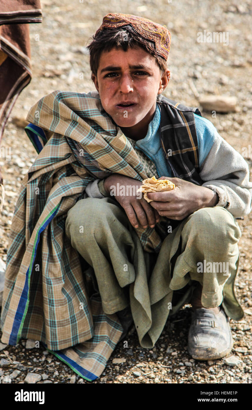 Ein lokaler afghanischer Junge kaut an Brot in Kundelan Dorf, Provinz Kandahar, Afghanistan, 27. Januar 2013.  (US Armee-Foto von Spc. Joshua Krüger/freigegeben) Kundelan Dorf 130202-A-RE111-118 Stockfoto