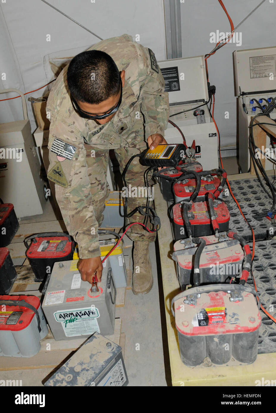 SPC. Hector Salas, ein Radfahrzeug Mechaniker mit Bravo Company, 501. Brigade Support Battalion, 1. Brigade, 1. US-Panzerdivision und ein Eingeborener von Juarez, Mexiko, zeigt, wie die Batterien aufgeladen sind, bei Forward Operating Base Walton, Provinz Kandahar, Afghanistan, März 11. Salas hat dazu beigetragen, dass die Brigade, die fast $50.000 in recycelten Batterien zu sparen. Wiederbelebte Akkus zurückbringen Böcke 130311-A-IX573-030 Stockfoto