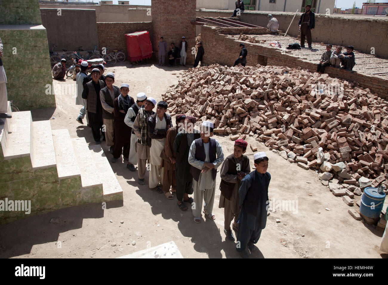 Afghanische jungen stehen Schlange außerhalb Rucksäcke All-Boys Paschtu Abad School in Ghazni Bezirk erhalten Provinz Ghazni, Afghanistan, 20. April 2013. Khalilullah Hotak, ein Mitglied der Provinz Nejat sozialen Rat von Ghazni verteilte Rucksäcke und Schreibtische für die Schule, die mehr als 600 jungen unterrichtet. Die Nejat Sozialrat Ziel ist es, Unterdrückung, Korruption und Ungerechtigkeit in Abstimmung mit der afghanischen Regierung zu beseitigen.  (US Armee-Foto von Spc. Jessica Reyna DeBooy/freigegeben) Pashtu Abad Schule 130420-A-SL739-215 Stockfoto