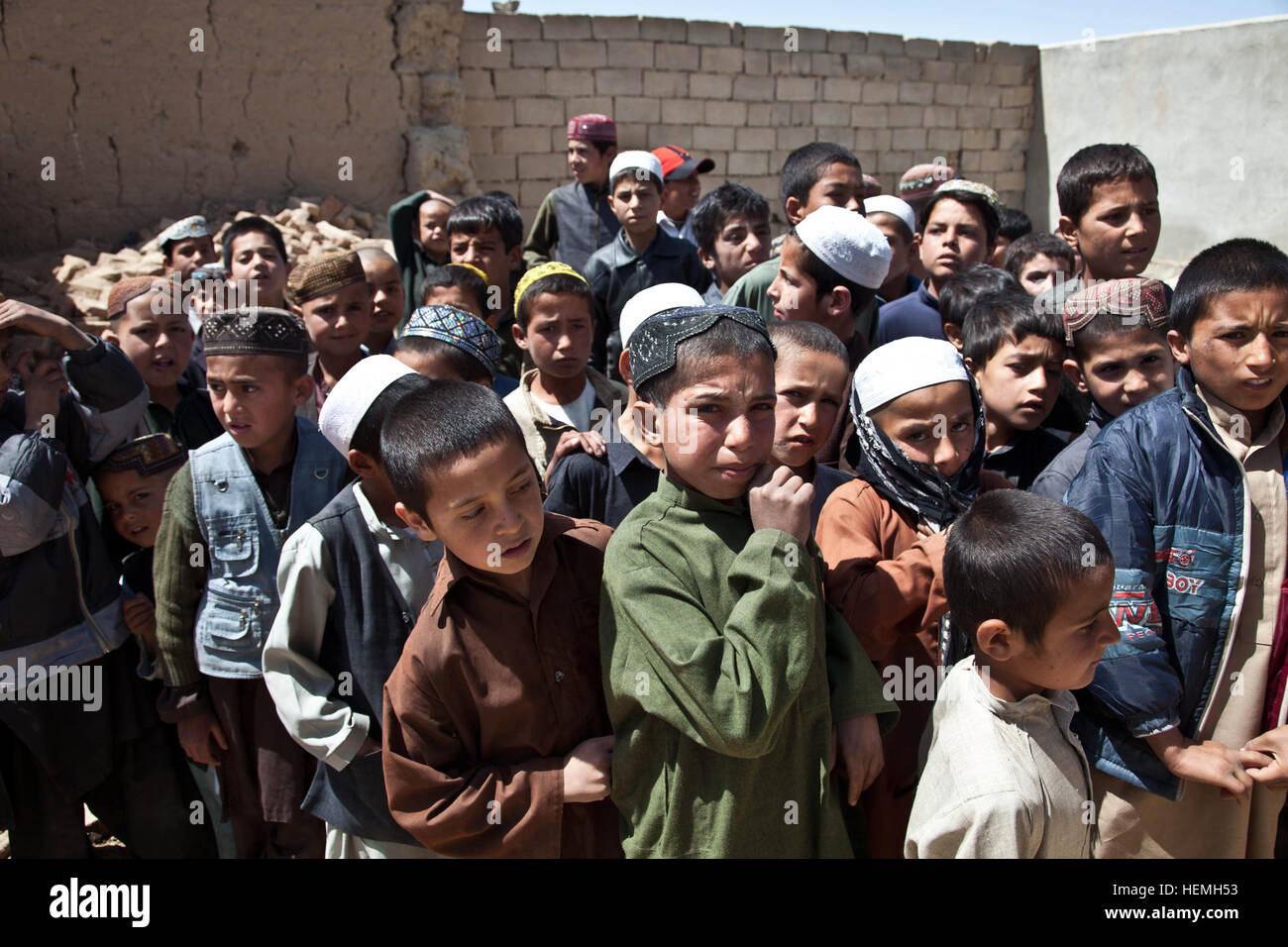 Afghanische jungen warten auf Rucksäcke um die All-Boys Paschtu Abad School in Ghazni Bezirk gegeben werden, Provinz Ghazni, Afghanistan, 20. April 2013. Khalilullah Hotak, ein Mitglied der Provinz Nejat sozialen Rat von Ghazni verteilte Rucksäcke und Schreibtische für die Schule, die mehr als 600 jungen unterrichtet. Die Nejat Sozialrat Ziel ist es, Unterdrückung, Korruption und Ungerechtigkeit in Abstimmung mit der afghanischen Regierung zu beseitigen.  (US Armee-Foto von Spc. Jessica Reyna DeBooy/freigegeben) Pashtu Abad Schule 130420-A-SL739-161 Stockfoto