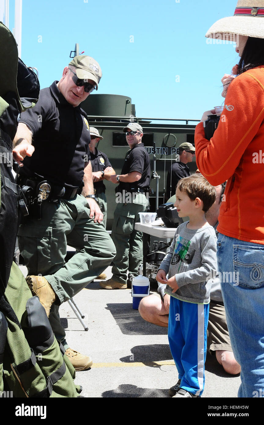 Senior Officer George Ewing mit Austin, Texas Polizei Abteilung Bomb Squad zeigt, wie richtig die Schutzausrüstung tragen Jett Berlin und seiner Familie während der Texas militärische Kräfte Open House bei Camp Mabry, Texas, 20. April 2013.  (US Army National Guard Foto von Sergeant Suzanne Carter/freigegeben) TXMF feiert amerikanische Helden 911751 Stockfoto