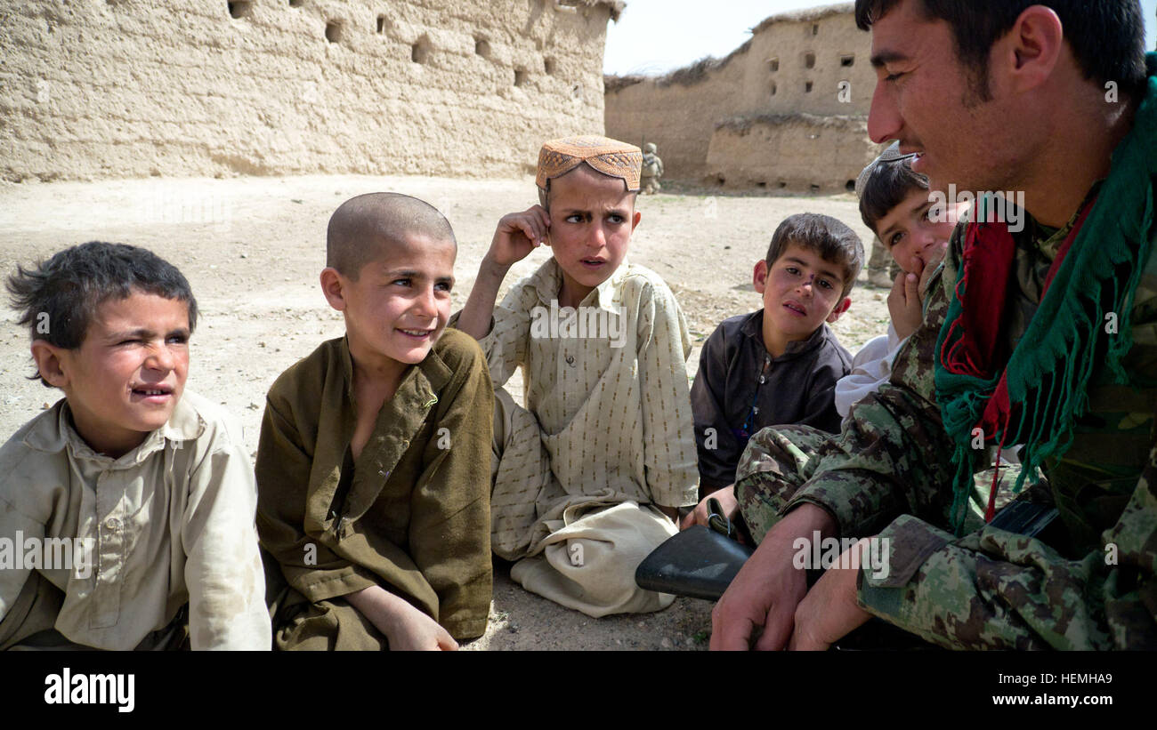 Ein afghanischer Soldat des 4. besucht Kandak, 205. Korps, mit Kindern in einem Dorf bei einer Suche nach Waffen und Sprengstoff Caches mit seinem amerikanischen counter Teile in Zabul Provinz, Afghanistan, April 25. Betrieb Blackhawk Talon waren Soldaten aus dem 2. Eskadron, 1. Kavallerie-Regiment und Soldaten aus der aztekischen Gesellschaft, zweite Bataillon, 23. Infanterie-Regiment, 4. Stryker Brigade Combat Team, 2. US-Infanteriedivision sowie afghanische Soldaten von der National Defense Center. (Foto: U.S. Army Spc. Tim Morgan) Betrieb Blackhawk Talon 130425-A-QA210-946 Stockfoto