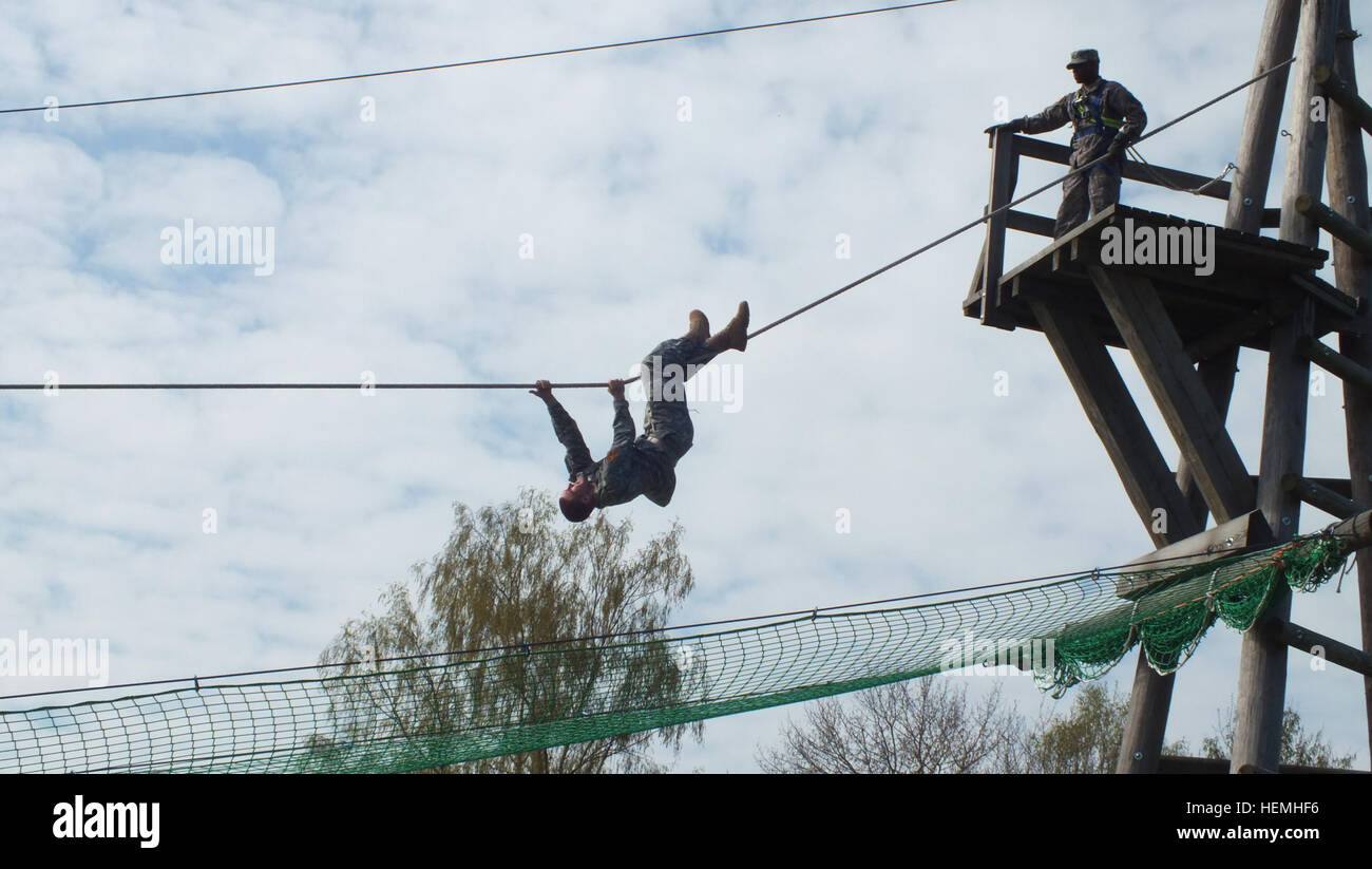 Ein US-Soldat, Recht, schaut zu, wie eine US-Armee Garnison Ansbach Junior ROTC-Kadett ein Hochseilgarten Hindernis bei der Ausbildung-Umgebung Oberdachstetten in Bayern, Deutschland, 26. April 2013 verhandelt. Die Veranstaltung wurde gesponsert von Freiwilligen aus Bravo Company, 3. Bataillon, 159. Aviation Regiment, 12. Combat Aviation Brigade.  (US Armee-Foto von Luis Viegas/freigegeben) Ein US-Soldat, Recht, schaut zu, wie eine US-Armee Garnison Ansbach Junior ROTC-Kadett ein Hochseilgarten Hindernis 6 verhandelt Stockfoto