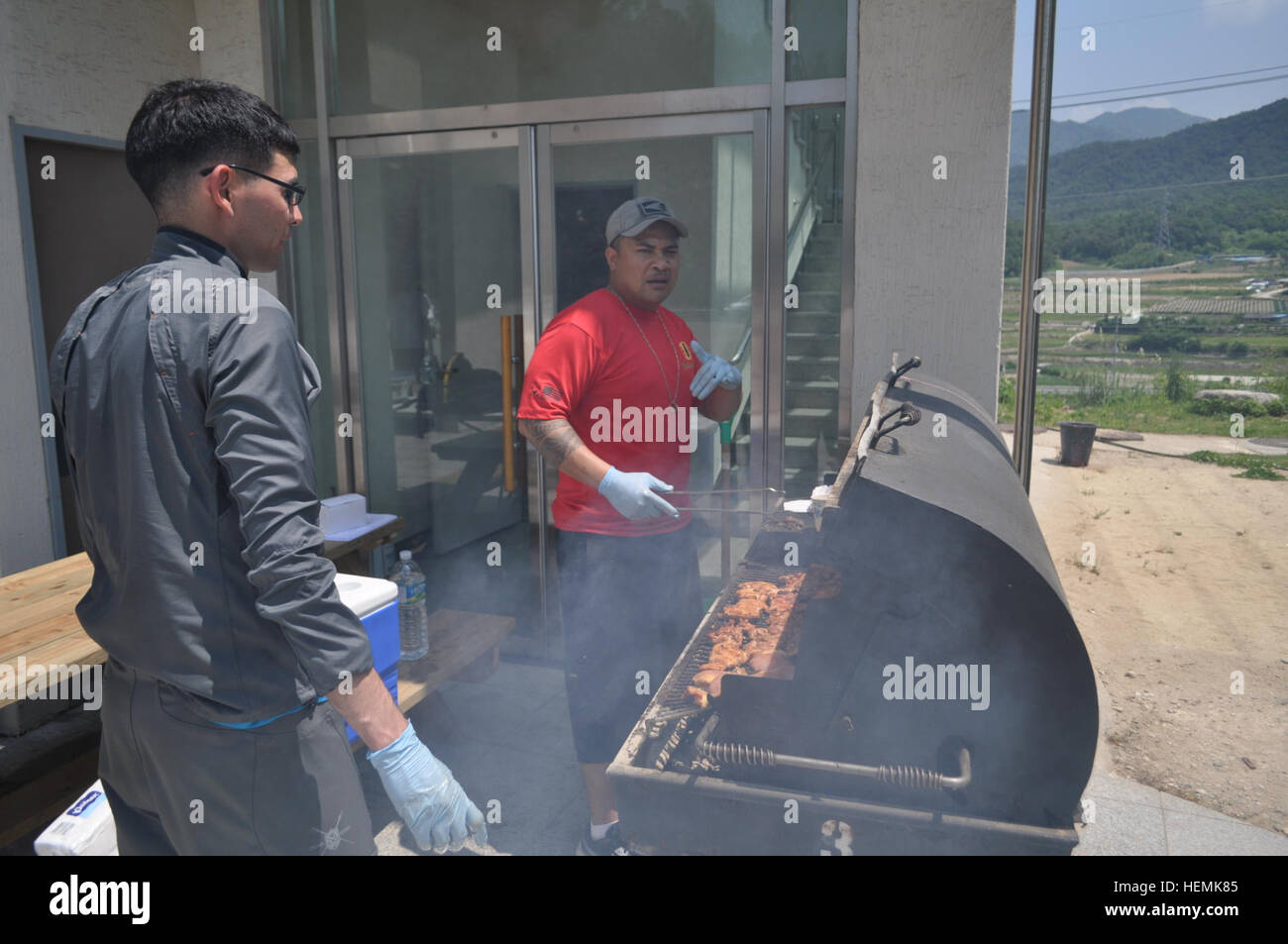 Braten Sie Staff Sgt Leaga Sua aus Samoa, Hauptsitz und zentrale Batterie Training Raum Unteroffizier, und Sgt. John Rodriguez aus Hawaii, ein Mehrkanal-Übertragung Systeme Operator-Maintainer, beide zugewiesen, Hauptsitz und zentrale Batterie, 210. Fires Brigade, 2. US-Infanteriedivision, Huhn und Wurst auf dem Grill für das Mittagessen im X Spiel Resort in Inje, Gangwon-Provinz, 7.Juni.  (US Armee-Foto von CPL. Kim Han-Byeol, 210 FiB PAO) Linderung von Stress und Angst im freien 130607-A-WG463-048 Stockfoto