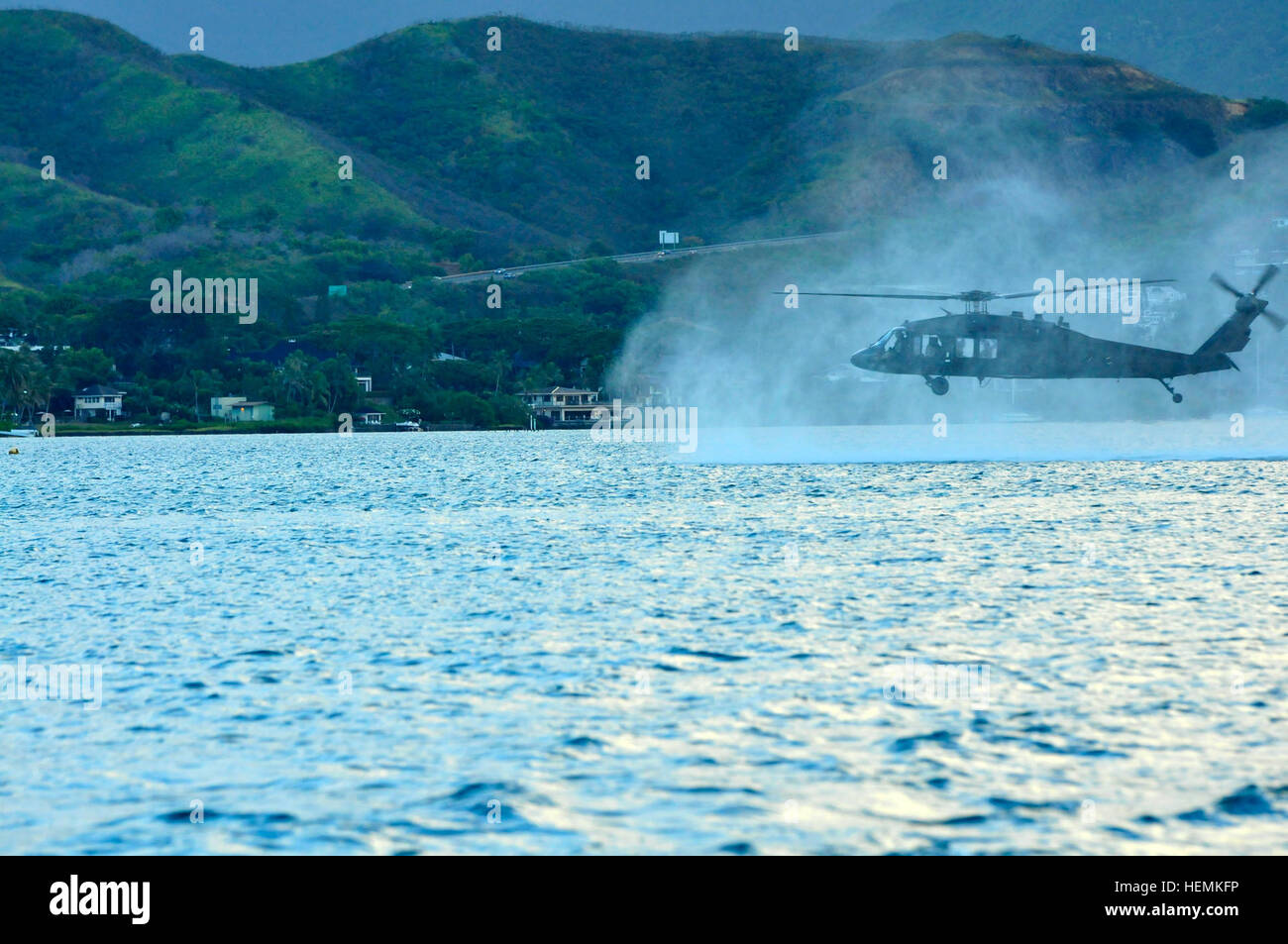 Ein US-Armee UH-60 Black Hawk Hubschrauber, Bravo Company, 2. Bataillon, 25. Aviation Regiment, 25. Combat Aviation Brigade zugewiesen bereitet Navy Taucher mit der US Navy SEAL Delivery Vehicle Team 1, Naval Special Warfare Group 3, im Wasser in Helocast Ausbildung bei Marine Corps Air Station Kaneohe Bay auf Hawaii, 18. Juni 2013 fallen.  (US Armee-Foto von Captain Richard Barker/freigegeben) 25. CAB Züge mit Navy Taucher 130619-A-AB123-485 Stockfoto