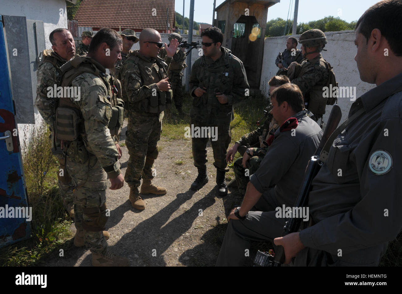 Georgische Soldaten von Charlie Kompanie, Batumi Georgien Licht Infanteriebataillon sprechen mit einem bulgarischen Armee Soldaten einen Afghanistan Nationalpolizei-Chef während einer Mission Probe Übung bei der Joint Multinational Readiness Center in Hohenfels, Deutschland, 15. August 2013 zu replizieren. Batumi und 31. georgischen Licht Infanterie-Bataillone führen ein MRE um zu trainieren und auf die Bataillone Fähigkeit zur Durchführung von Kampf und Aufstandsbekämpfung ausgewertet werden und zu einem Marinekorps regimental combat Team eingesetzt zur Unterstützung der International Security Assistance Force Einsätze zu integrieren Stockfoto