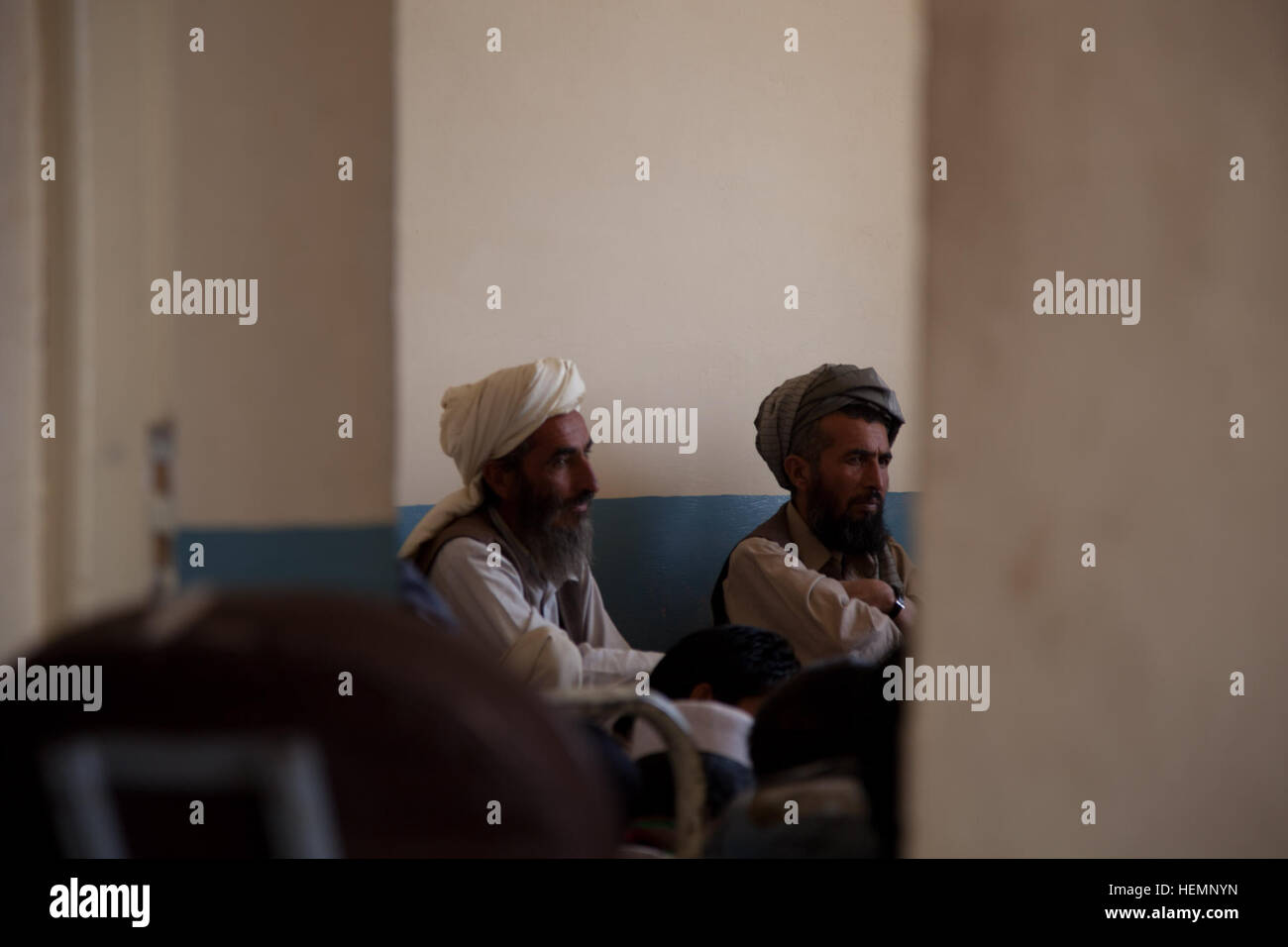 Zwei afghanische Männer sitzen und hören einen Vortrag über die erste Hilfe in einer Gemeinschaft-Klinik in Deh Yak district, Provinz Ghazni, Afghanistan, 19. August 2013. Fifity-Männer und Frauen aus Deh Yak Bezirk und Umgebung besucht das dreitägige medizinische Seminar, das Themen wie erste Hilfe, Hygiene, Notfall Geburt Techniken und Ernährung.  (US Armee-Foto von Spc. Jessica Reyna DeBooy/freigegeben) Enduring Freedom 130818-A-SL739-018 Stockfoto