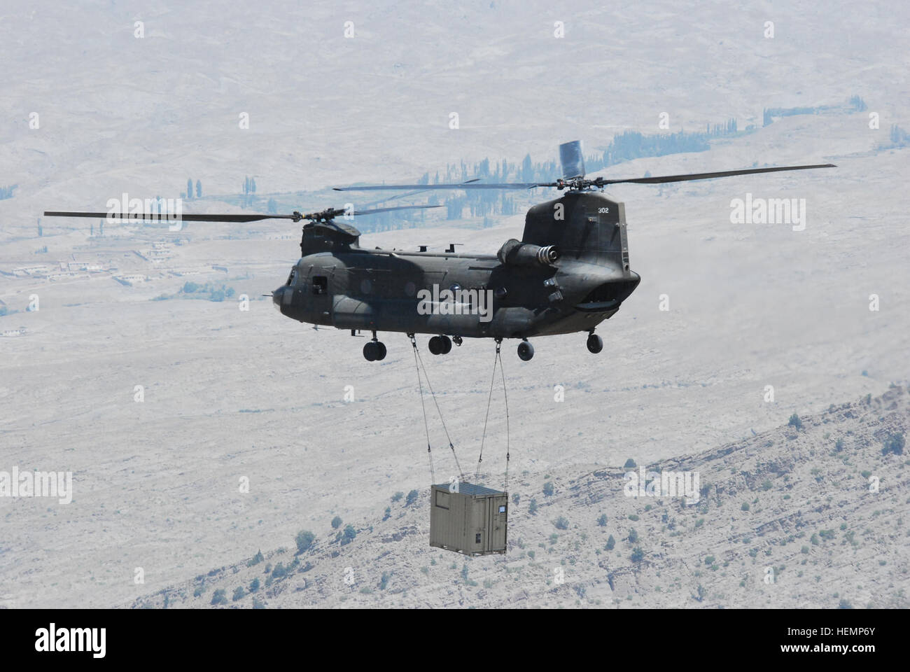 Ein Task Force Falcon CH-47 Chinook-Hubschrauber aus B Company, 2. Bataillon (allgemeiner Support), 149. Aviation Regiment, 36. Combat Aviation Brigade, transportiert einen Container per Schlinge Last Aug. 24, über Ost-Afghanistan. Schlinge Last 130824-A-SM524-104 Stockfoto