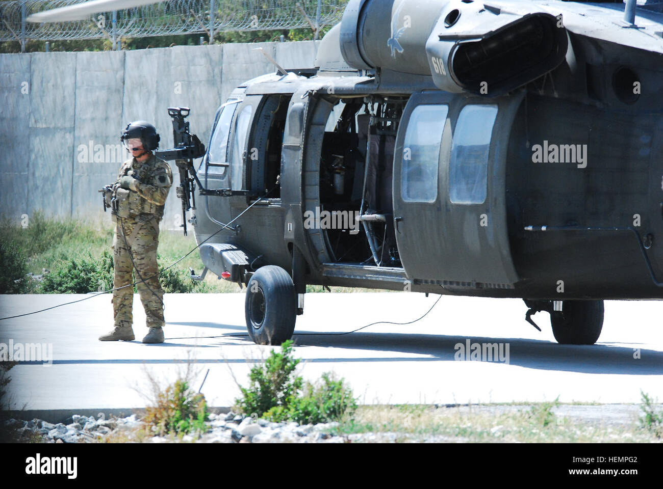 Sgt. Jay Herring, ein UH-60 Black Hawk Hubschrauber Crewchief zugewiesen A Company, 2. Bataillon (allgemeiner Support), 104. Aviation Regiment (Pennsylvania National Guard), Task Force Phoenix, wartet auf ein Fahrgast einsteigen in seinem Hubschrauber 4 Sept. in Kabul, Afghanistan zu begrüßen. Task Force Falcon UH-60 Black Hawk Hubschrauber Transport Personal in Ostafghanistan 130904-A-SM524-221 Stockfoto