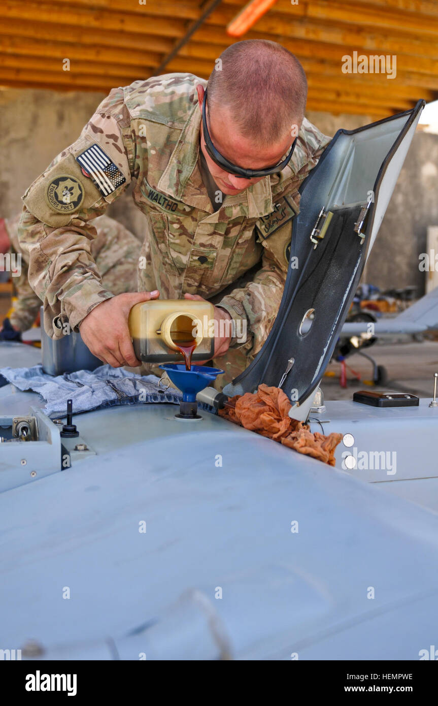 US Army Spc Justin Waltho mit Headquarters und Headquarters Troop, Combined Task Force Dragoon gießt Öl in ein RQ7B Schatten technische Unmanned Aircraft System zu einer mechanischen Station, während der Durchführung von Prüfungen nach dem Flug bei Forward Operating Base Pasab, Provinz Kandahar, Afghanistan, 12. September 2013. Soldaten verwendet des Flugzeugs für die Luftaufklärung und Mission Kommunikation. (US Armee-Foto von Spc. Joshua Edwards/freigegeben) Ölwechsel-130911-A-ZR192-217 Stockfoto