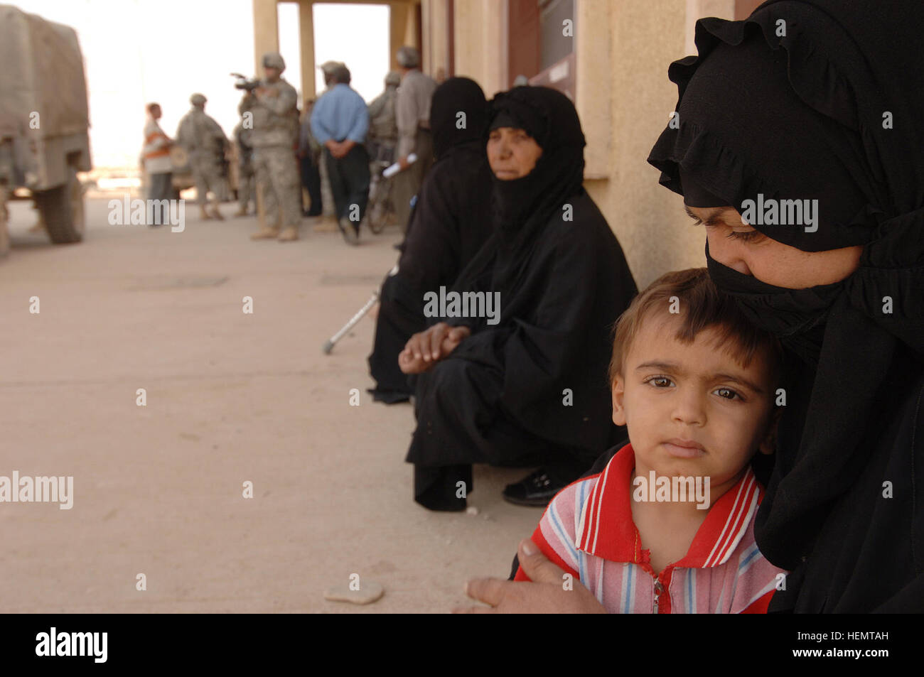 Ein irakischer Junge sitzt auf seinem Schoß Mütter während sie darauf warten, außerhalb der medizinischen Klinik in Narhwan, Irak, von US Armee Sanitäter von Charlie Kompanie 203. Sanitätsbataillons, 3. Brigade, 3. Infanterie-Division, zusammen mit einigen irakischen Ärzten, Okt. 8 gesehen werden. Med-Op 61894 Stockfoto