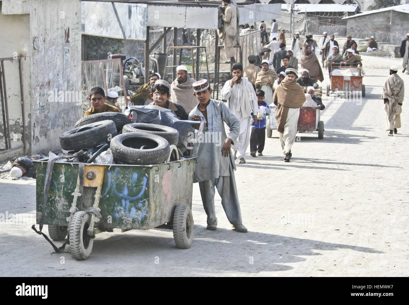 Eine Gruppe von jungen schiebt einen Wagen Reifen entlang der Fußgängerzone, 7. März um Torkham Tor an der afghanisch/pakistanischen Grenze. Fußgängerzone in Torkham Stockfoto