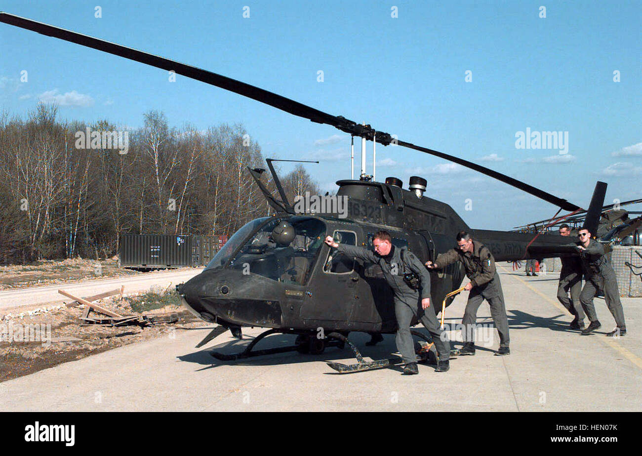 970418-A-9384H-044 Chief Warrant Officer Chris Elam (links) bekommt Hilfe zurückschieben seiner OH-58 Kiowa Hubschrauber in den Hangar auf dem Flugplatz Tuzla Main nach einer Mission in Bosnien und Herzegowina auf 18. April 1997.  Elam ist im Rahmen der Stabilisierungstruppe in Operation Joint Guard von 2-1 Aviation Battalion, Schweinfurt, Deutschland eingesetzt.  DoD-Foto von Spc. Tracey L. Hall-Leahy, US-Armee. Oh58-004 Stockfoto